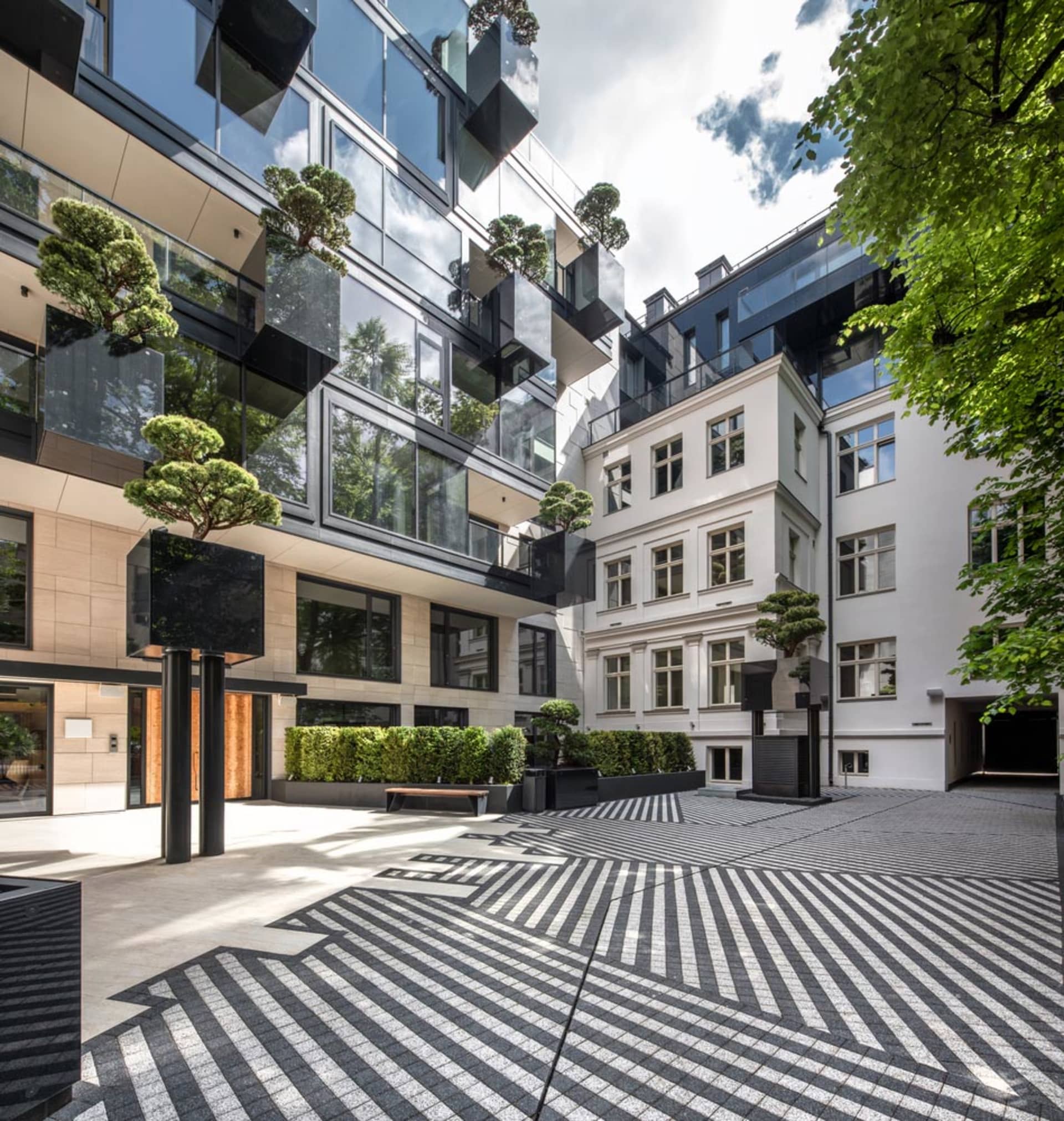 A modern commercial space with a glass facade and geometric courtyard.