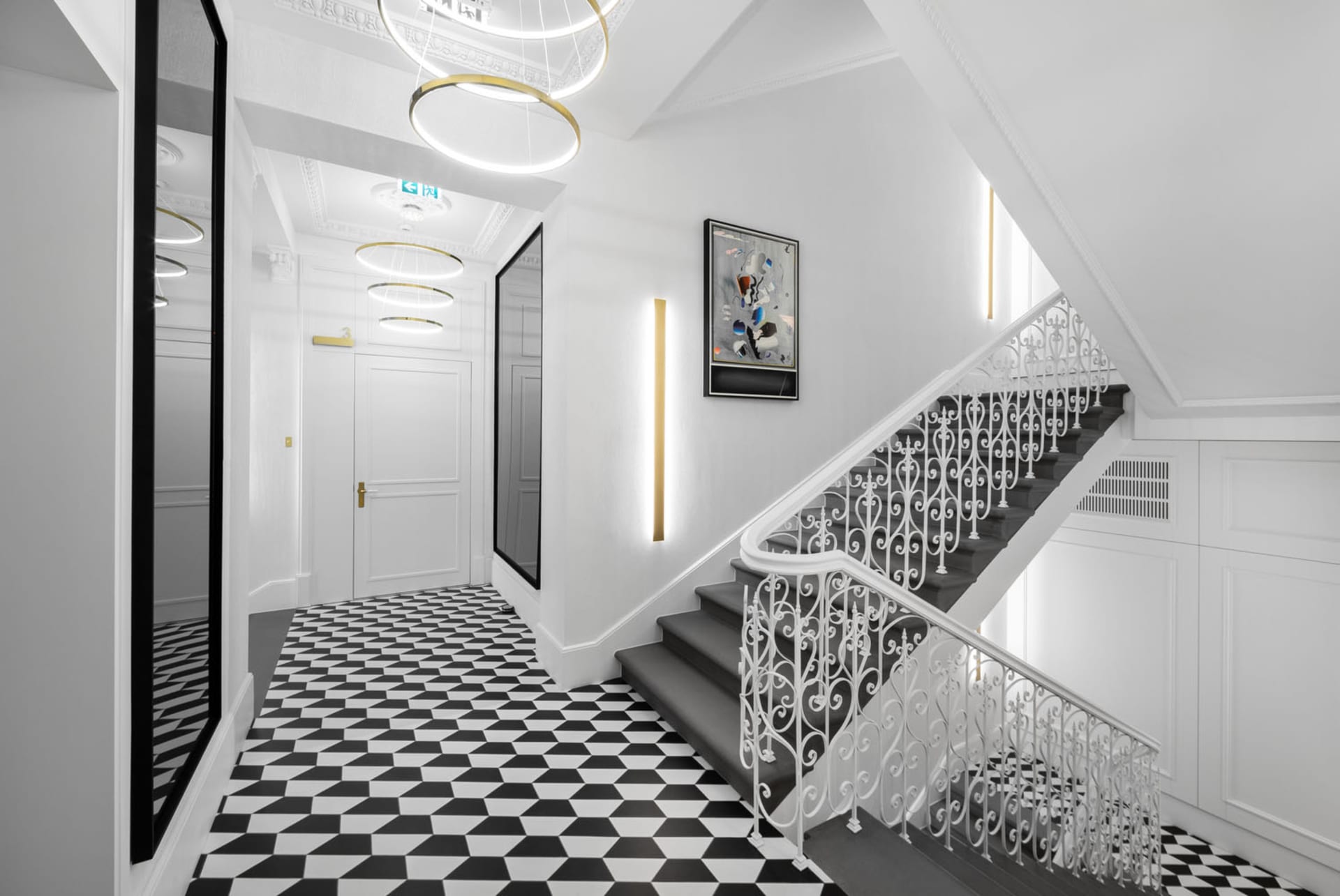 A modern hallway with black and white patterned floor, white walls, and a metal wire railing.