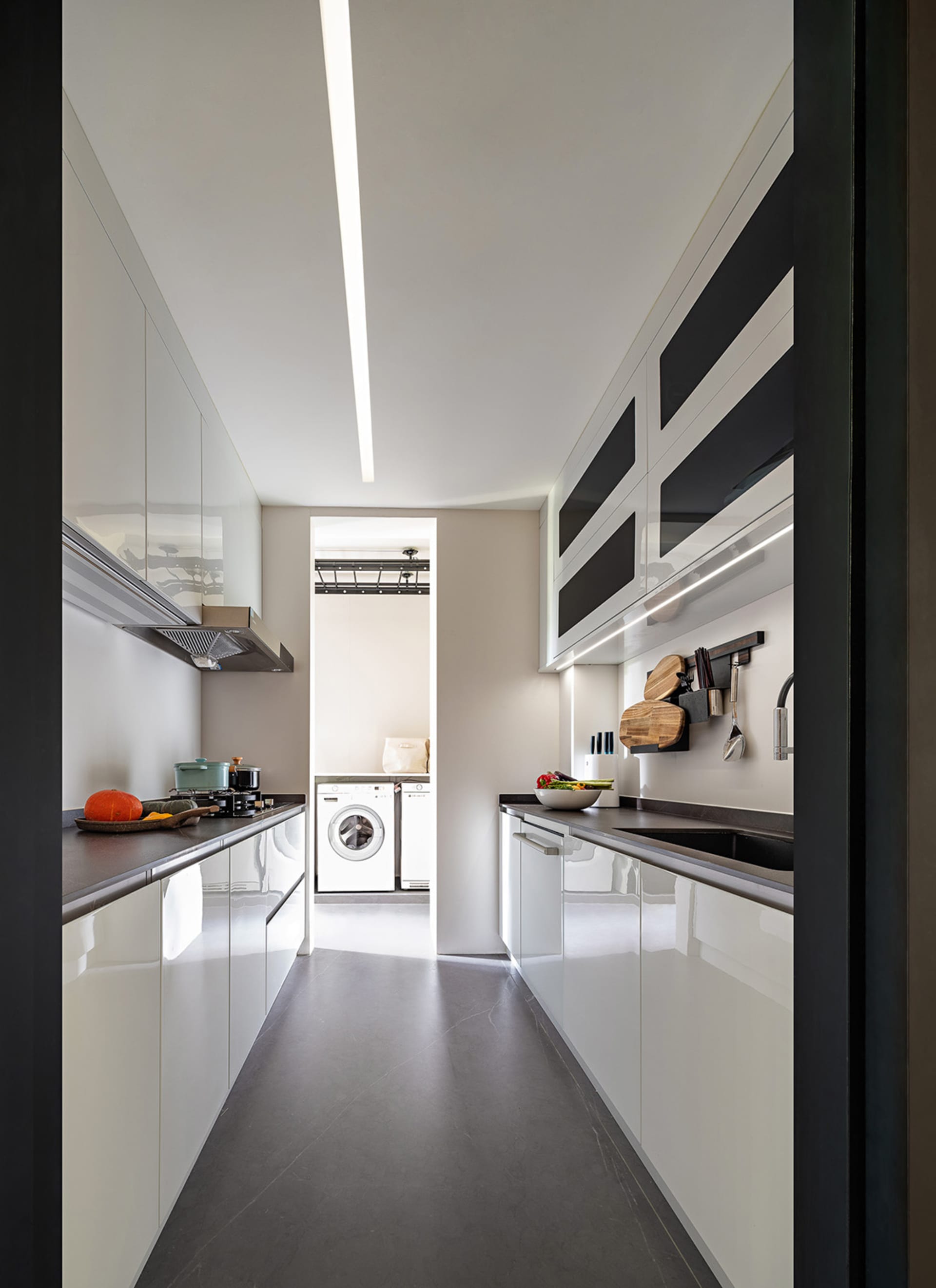 A minimalist kitchen with white cabinets and countertops.