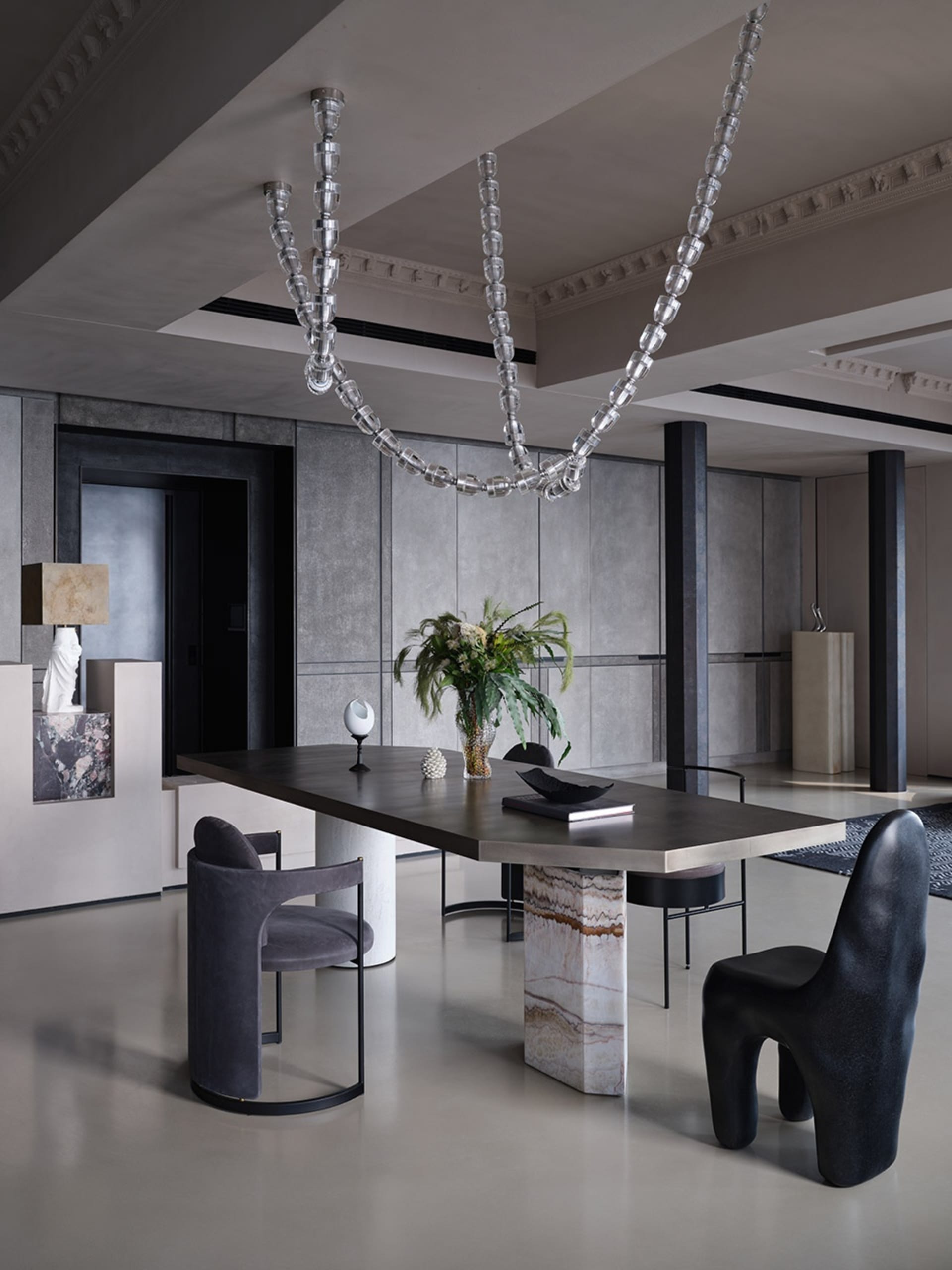 Modern restaurant interior with concrete floors and walls, minimalistic design, and contemporary art installations.
