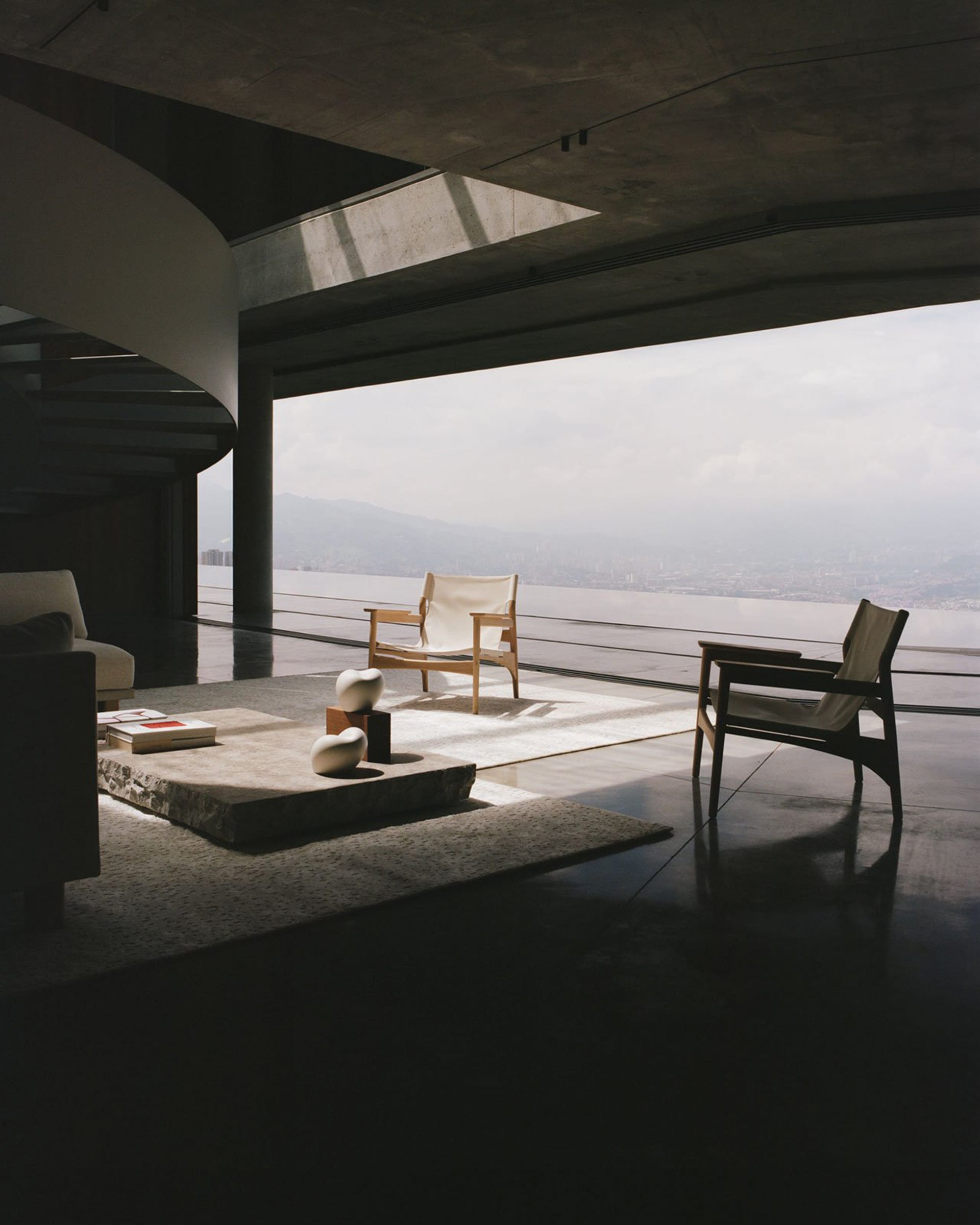 Modern minimalist living room featuring concrete and glass elements.
