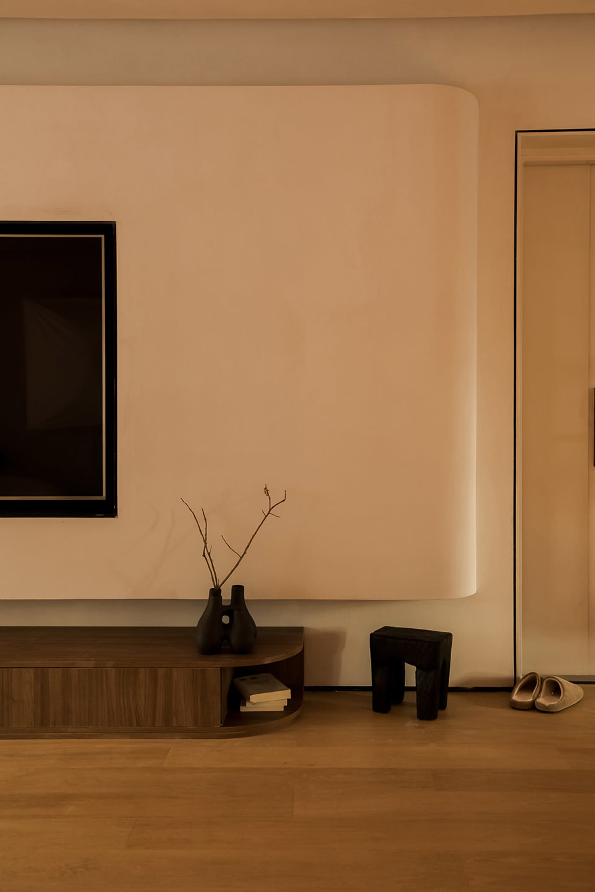Minimalist living room with a wooden console table and decorative vase.