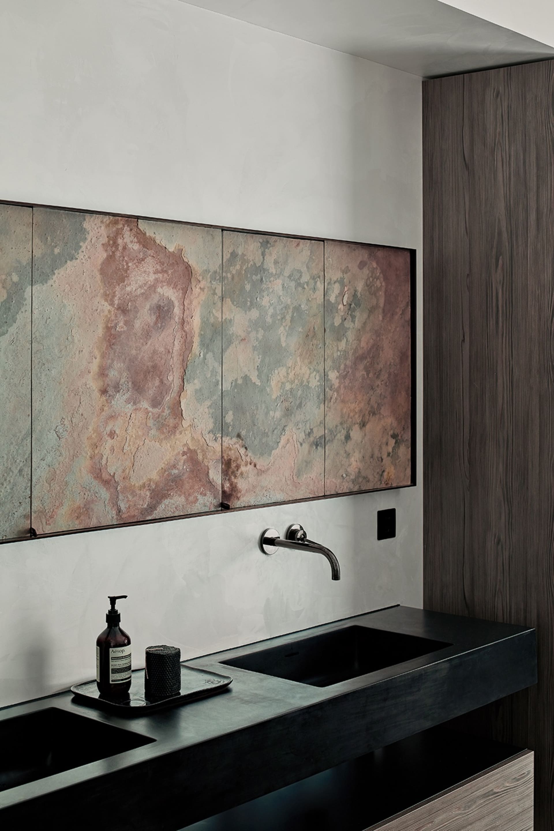 Modern bathroom featuring metallic cabinets against a sleek black countertop with a minimalist design.
