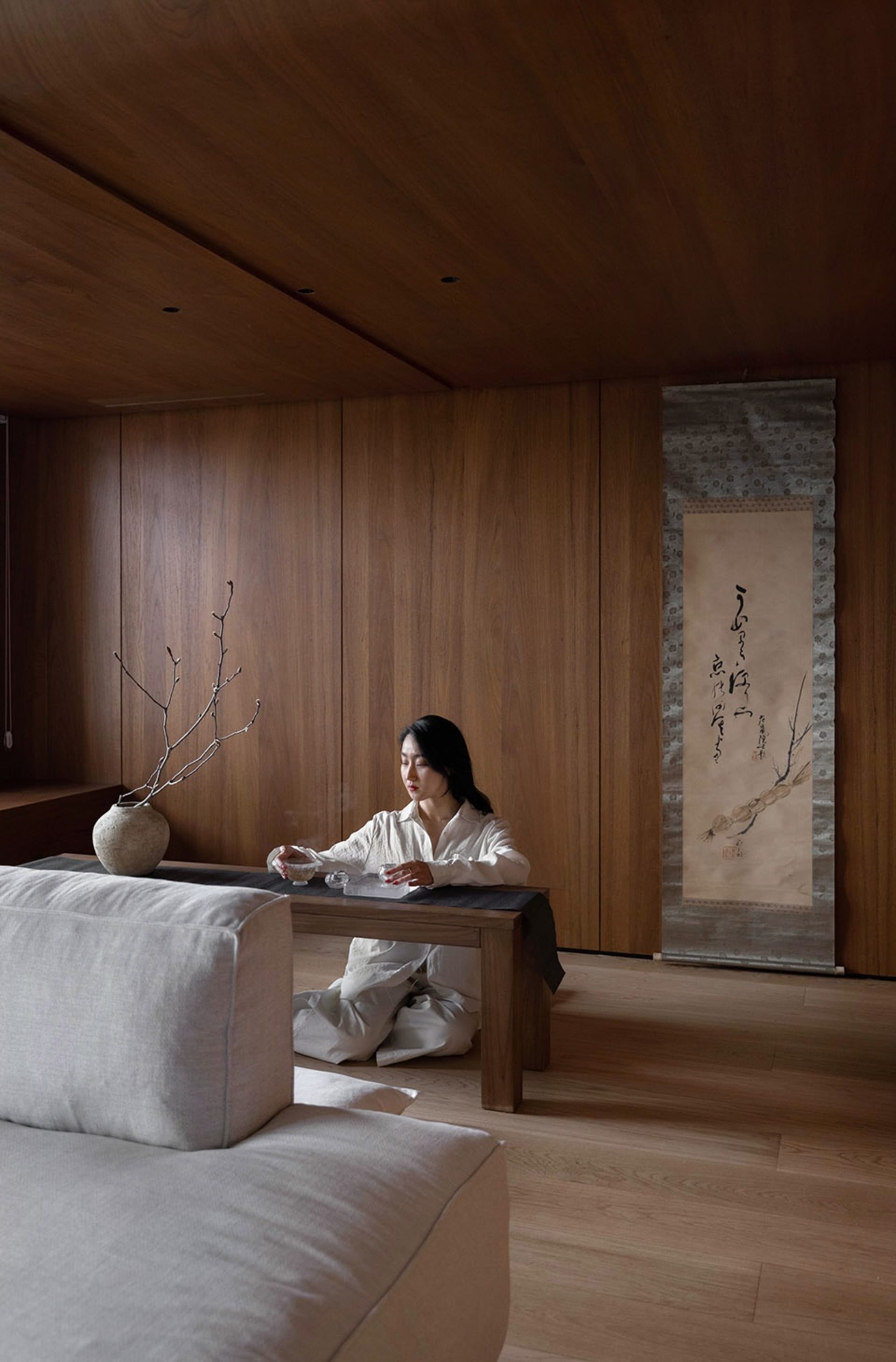 A modern living room with warm wooden elements, minimalist furniture, and a serene ambiance.
