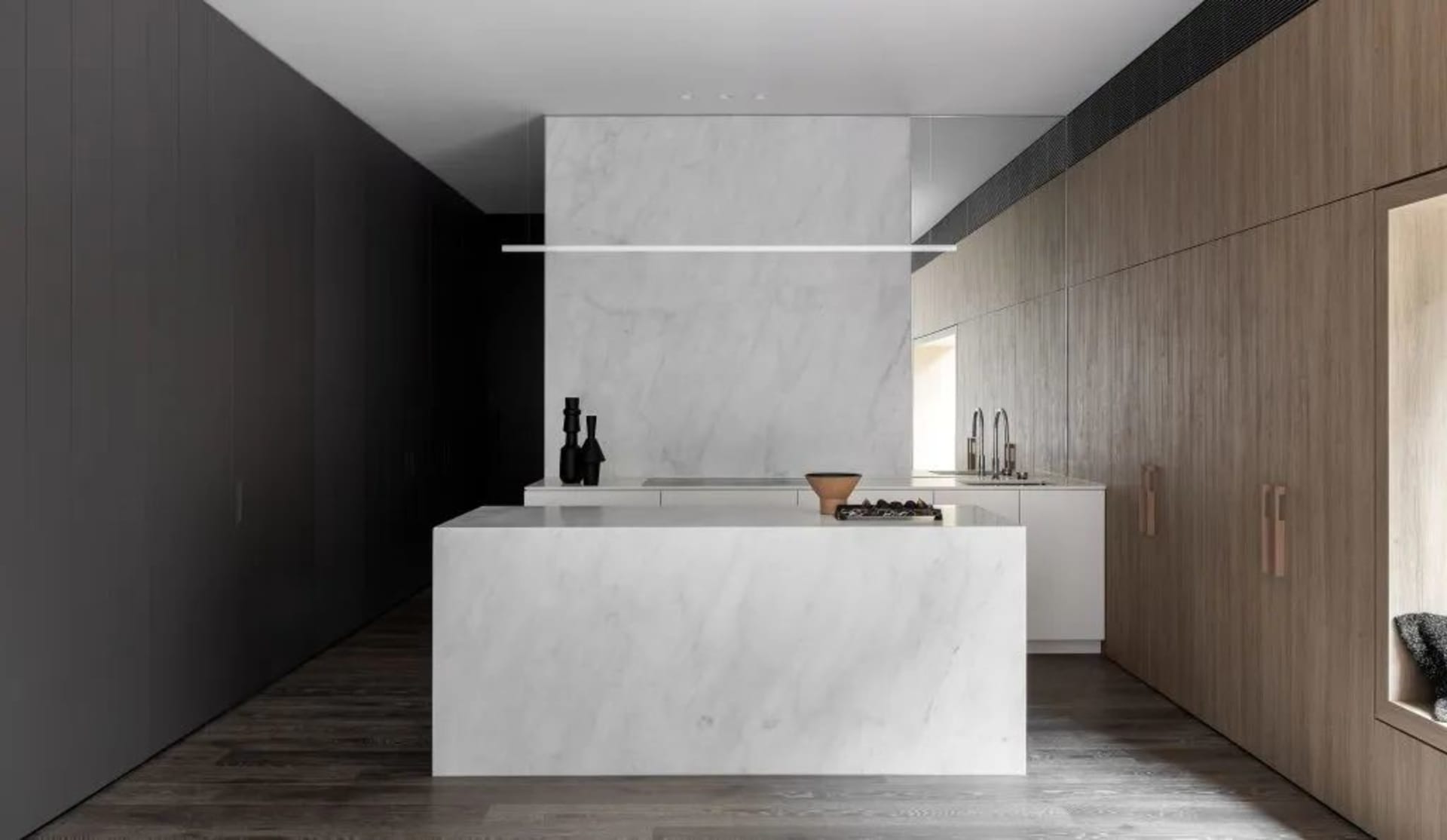 Modern residential kitchen featuring a minimalist design with a white marble countertop and backsplash.