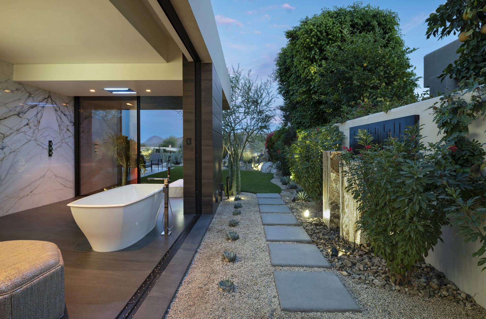 Modern bathroom interior with a freestanding bathtub and garden view.