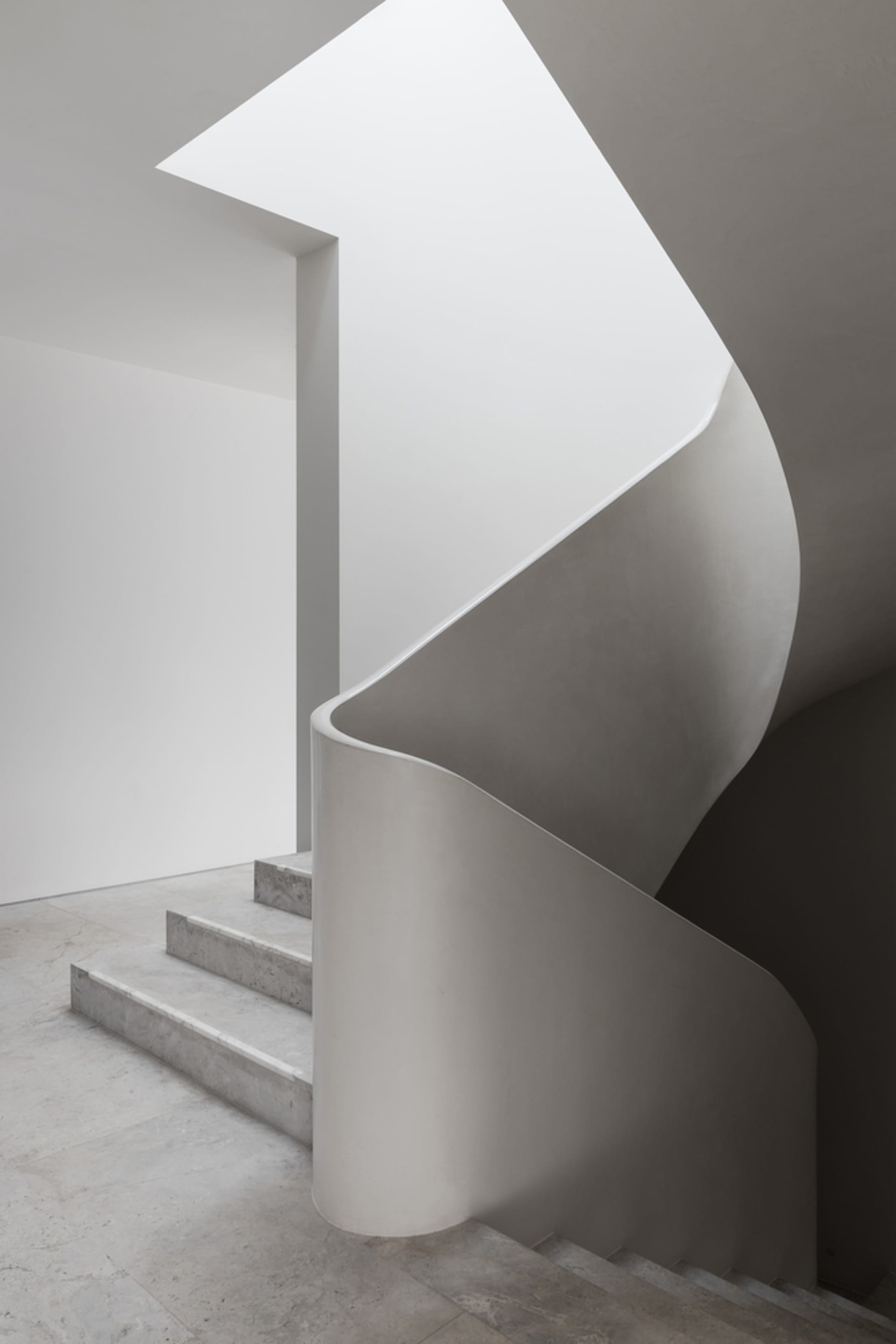 Modern interior with concrete stairs and walls.
