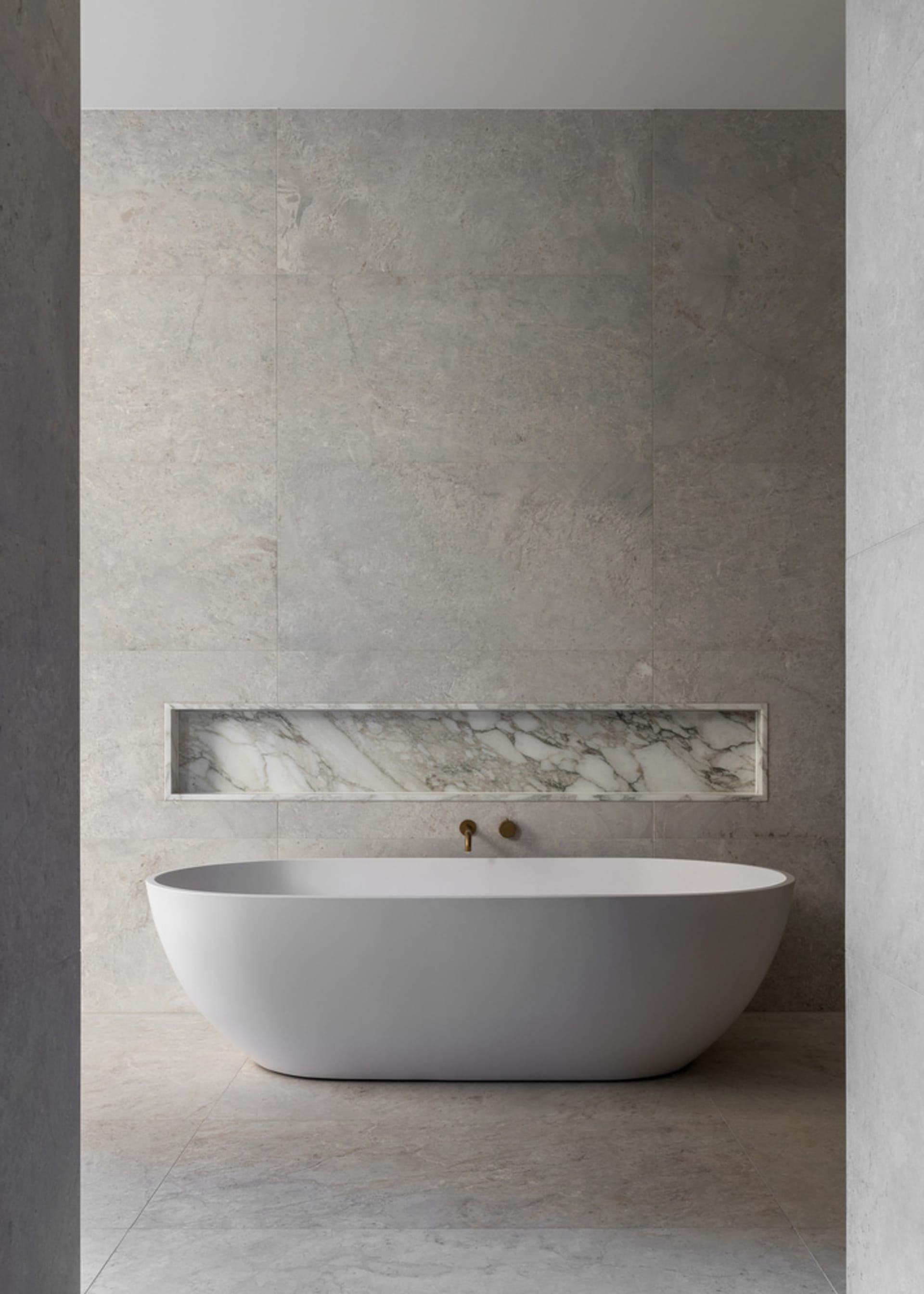 Modern minimalist bathroom featuring a freestanding bathtub with marble accents and a minimalist design.