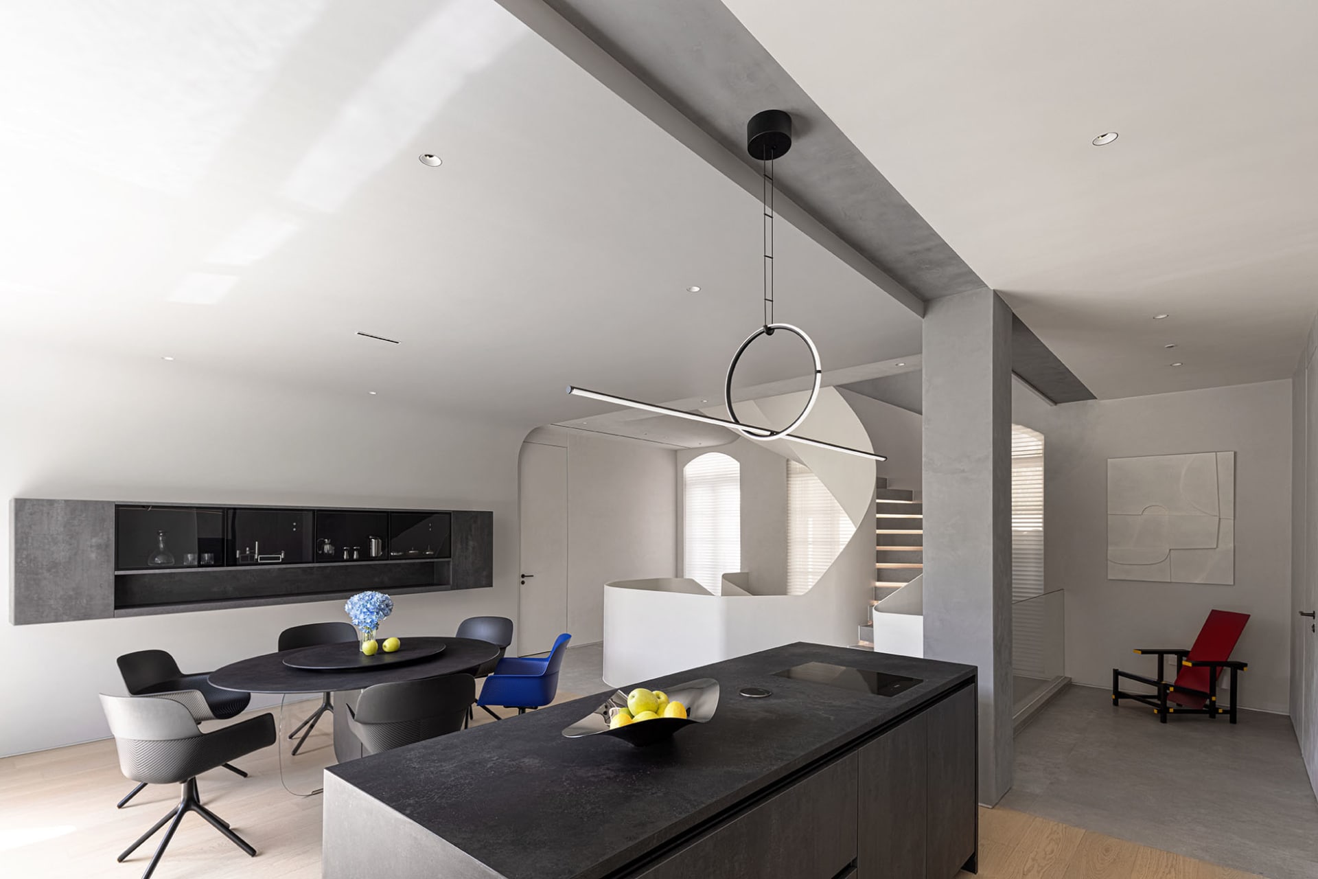 A modern residential kitchen with black concrete countertops and a black island, featuring sleek design elements and a minima