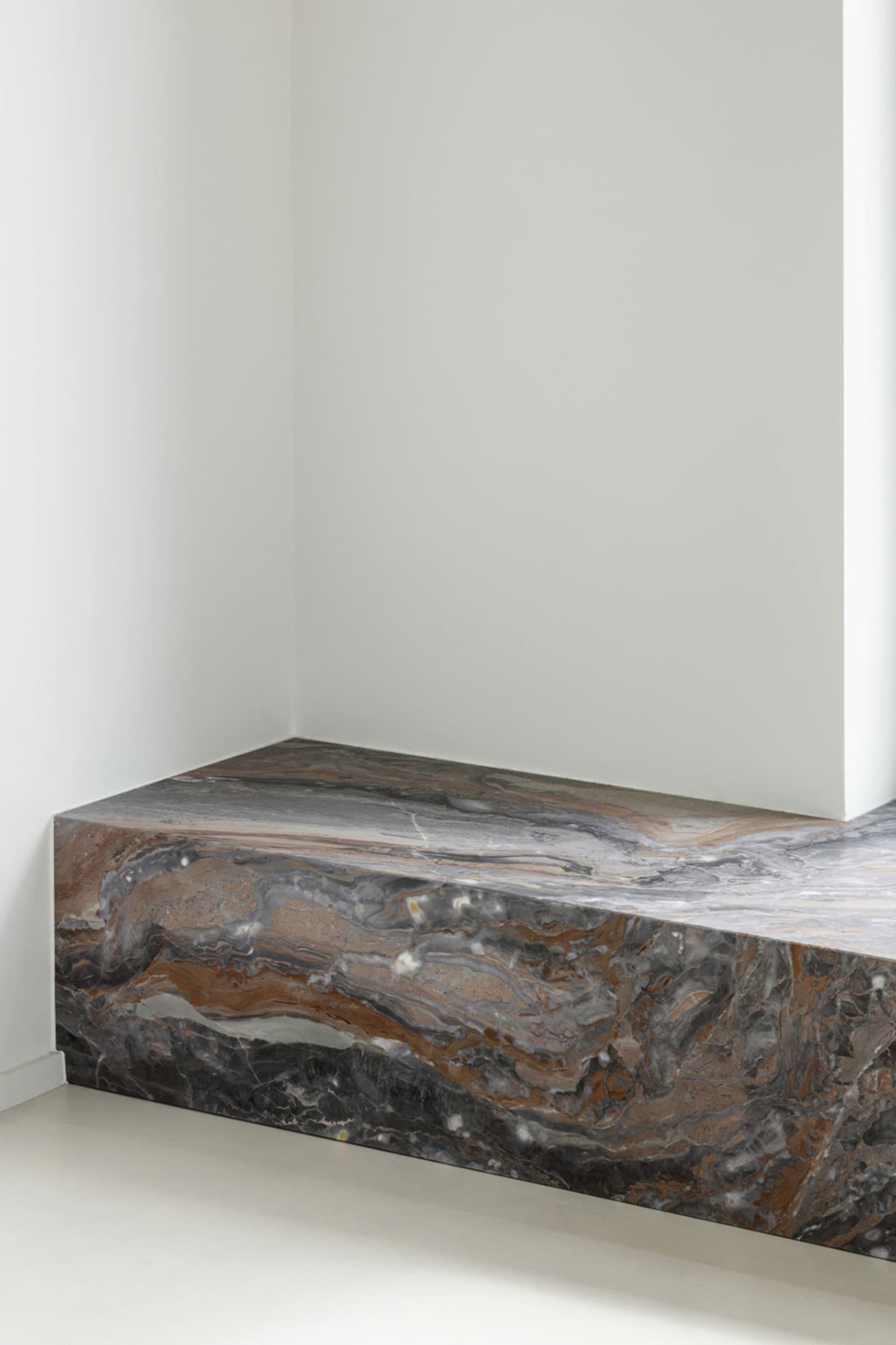 A minimalist room featuring a marble floor.