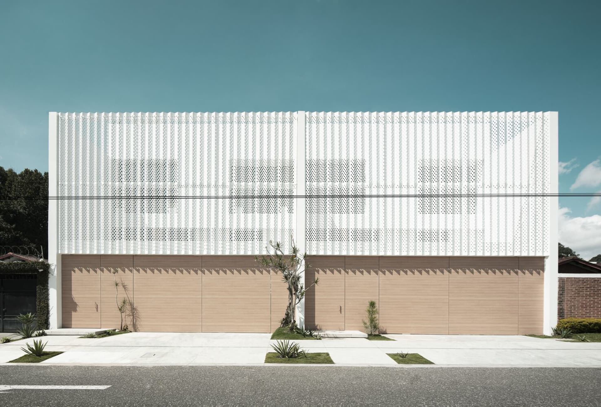 A modern house with a white metal facade and wooden accents