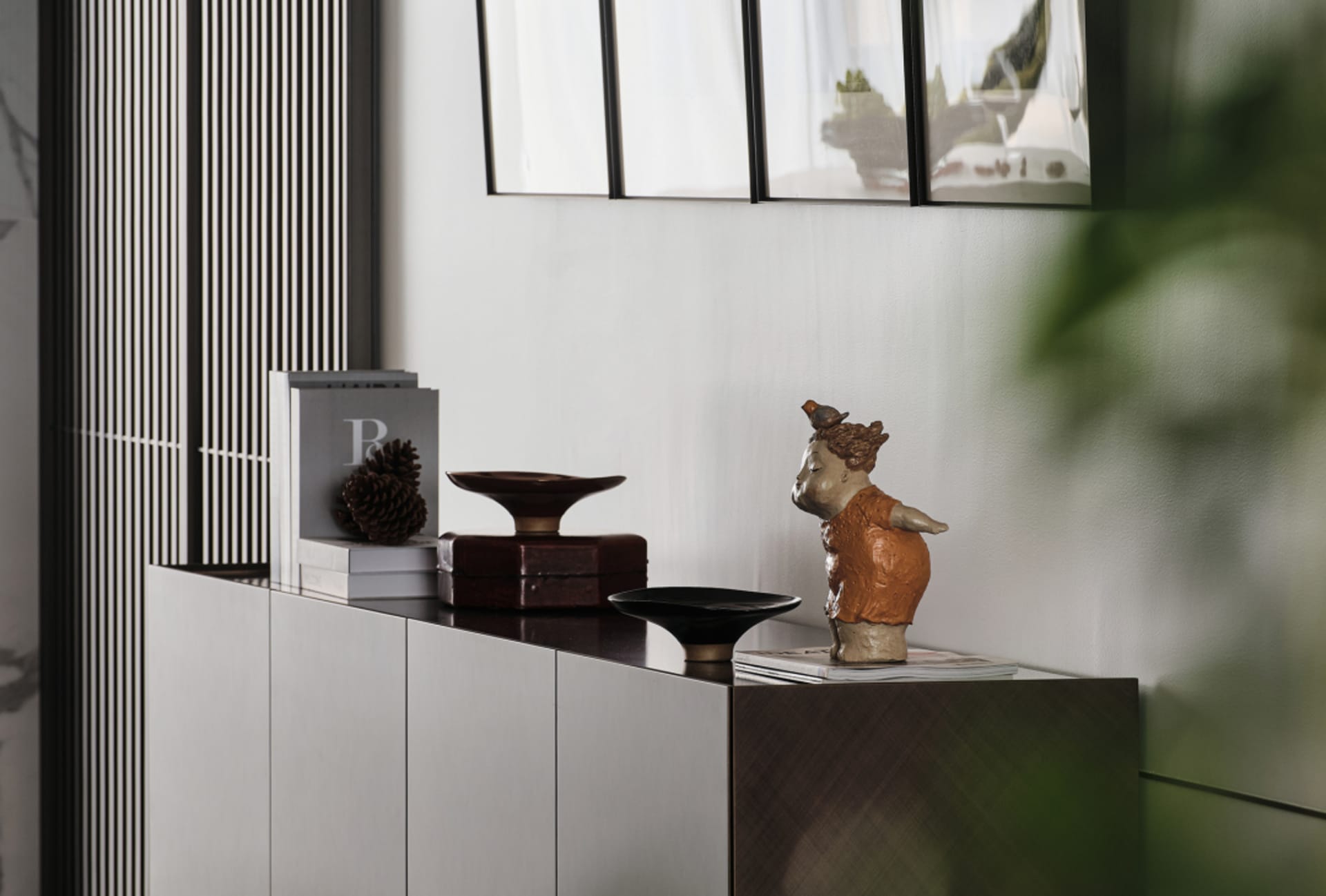 A modern living room featuring wooden furniture, including a cabinet with decorative items and a plant.