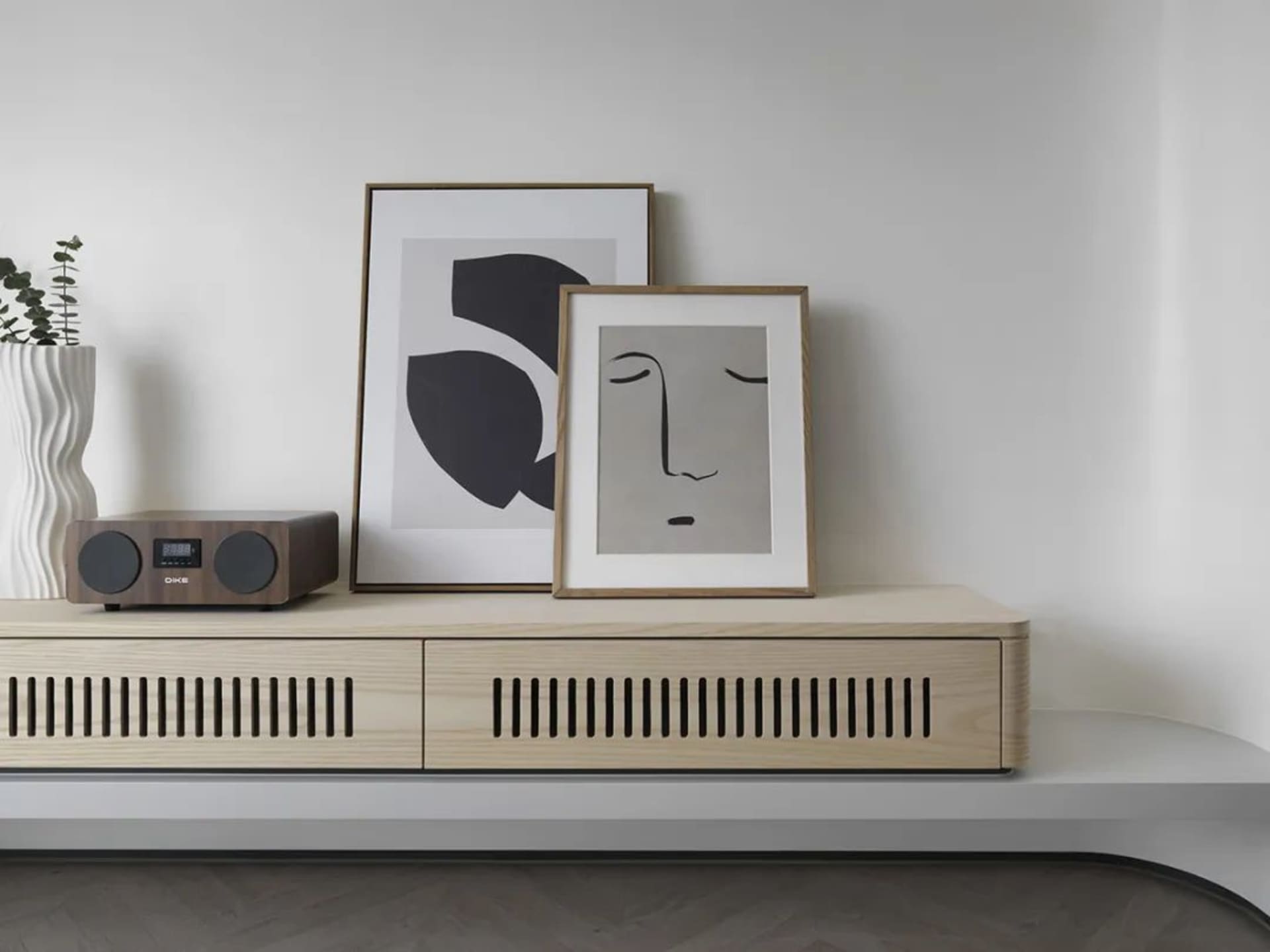A modern wooden cabinet with a sleek design, featuring two drawers and a radio receiver on top.