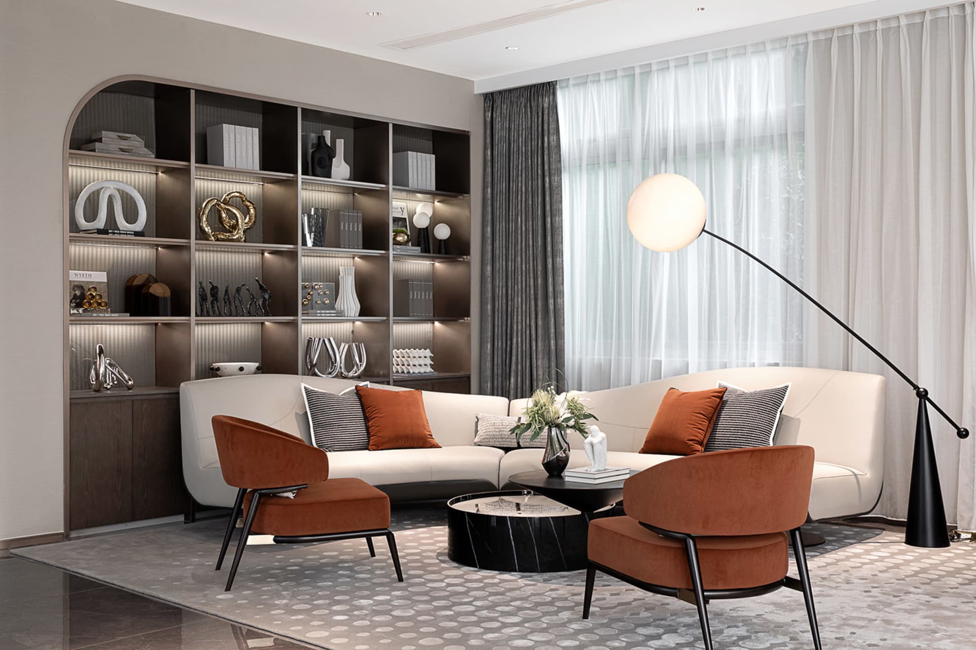 A modern living room with a white sectional sofa, orange armchairs, and a contemporary floor lamp.