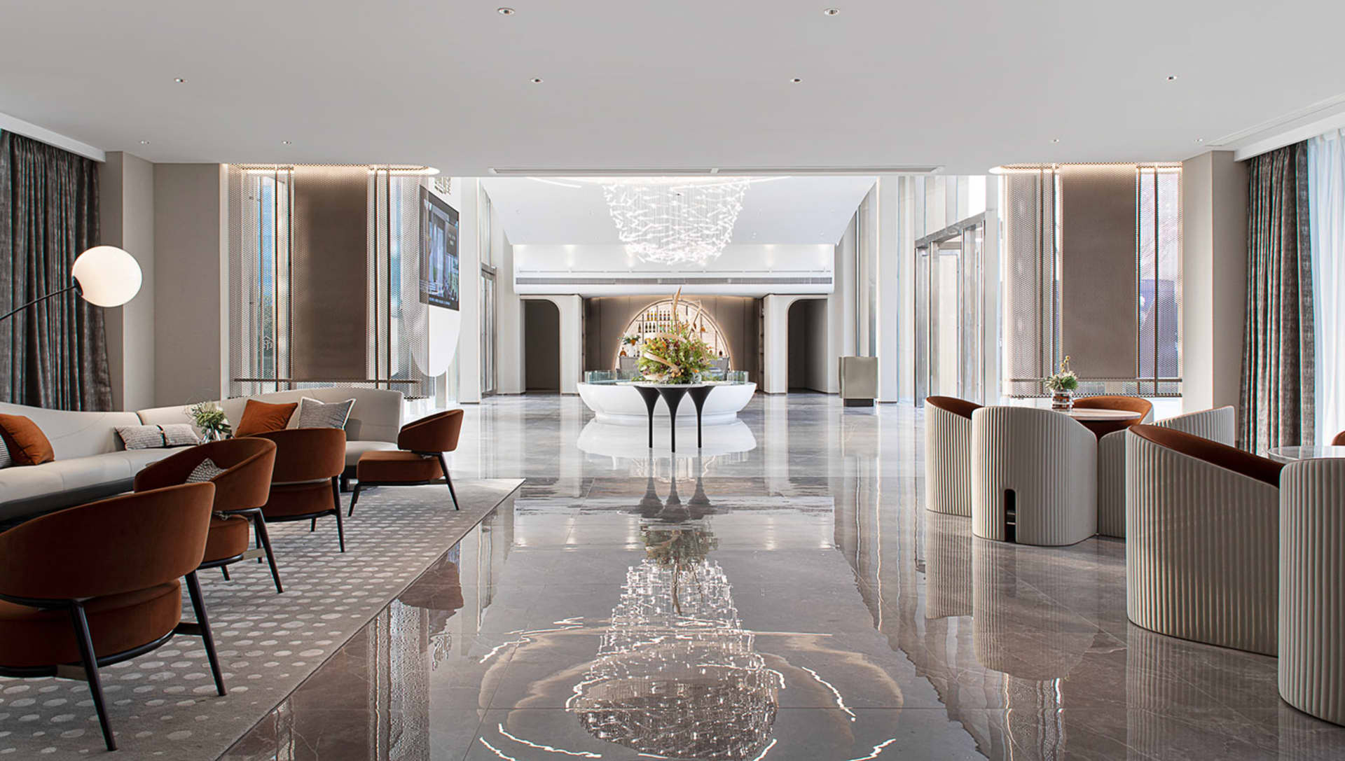 A modern hotel lobby with marble floors and white and brown furniture.