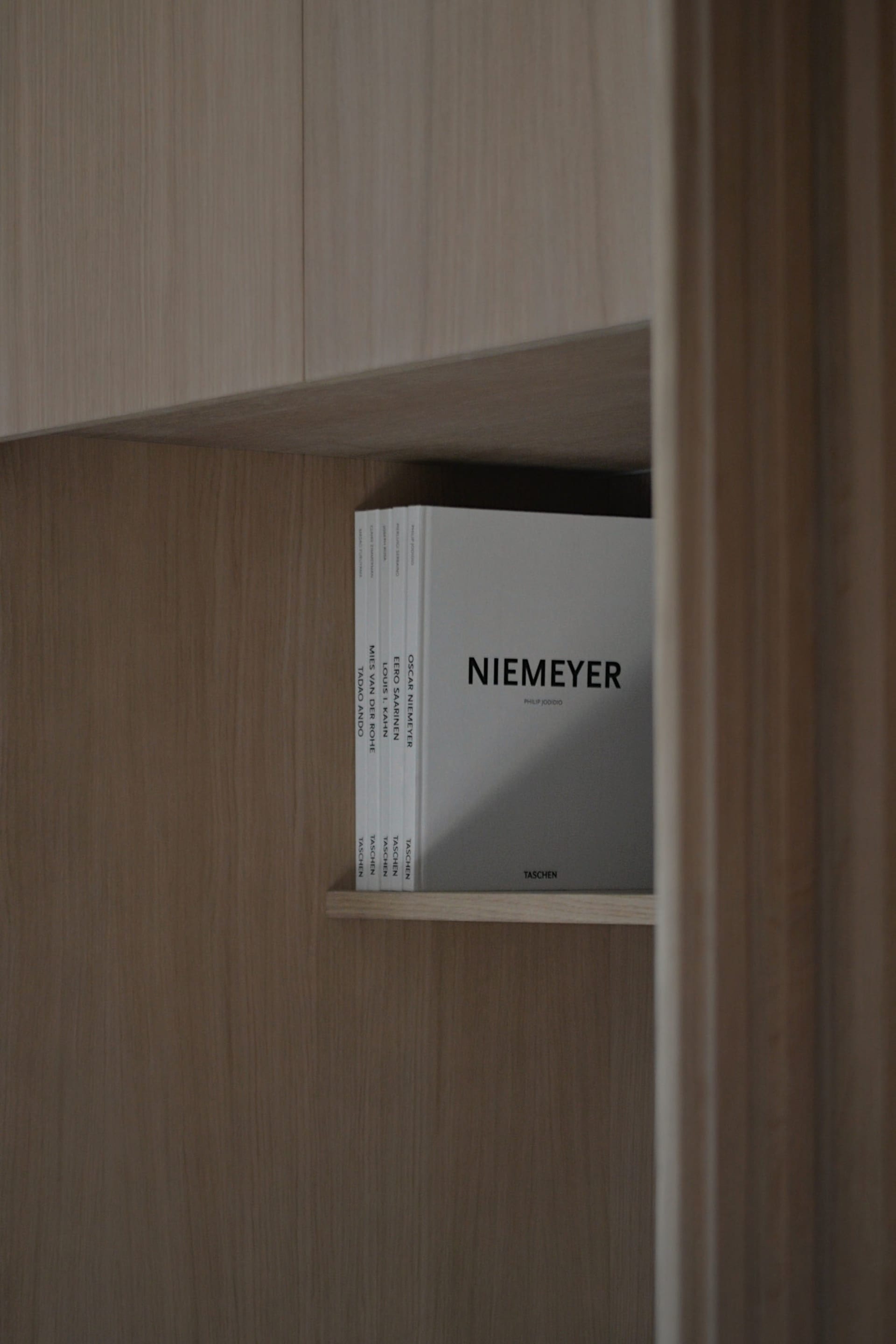 現代簡約木質書架，擺放一本書名為「Niemeyer」的簡約書籍