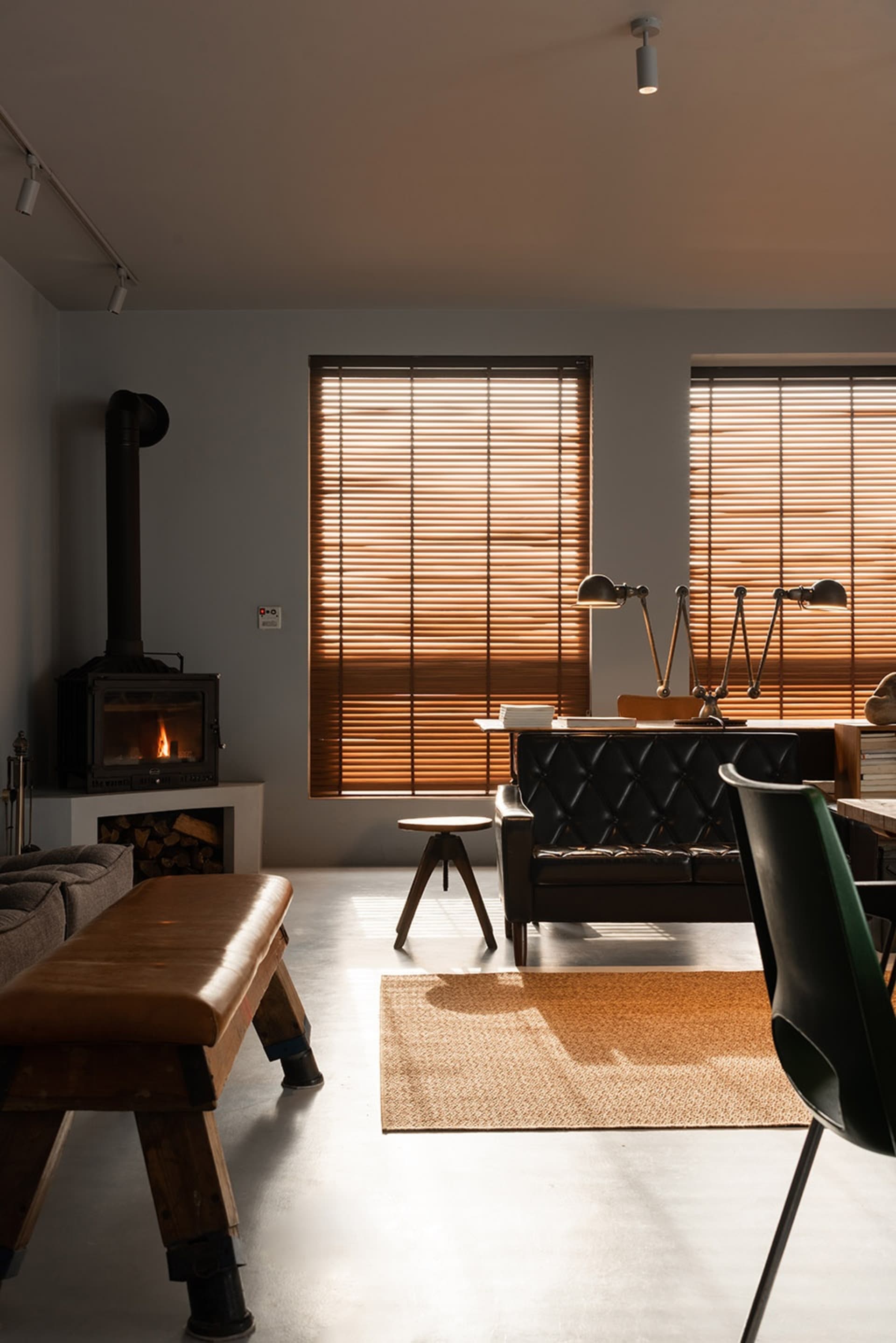 A living room with an industrial aesthetic featuring wooden elements and a fireplace.