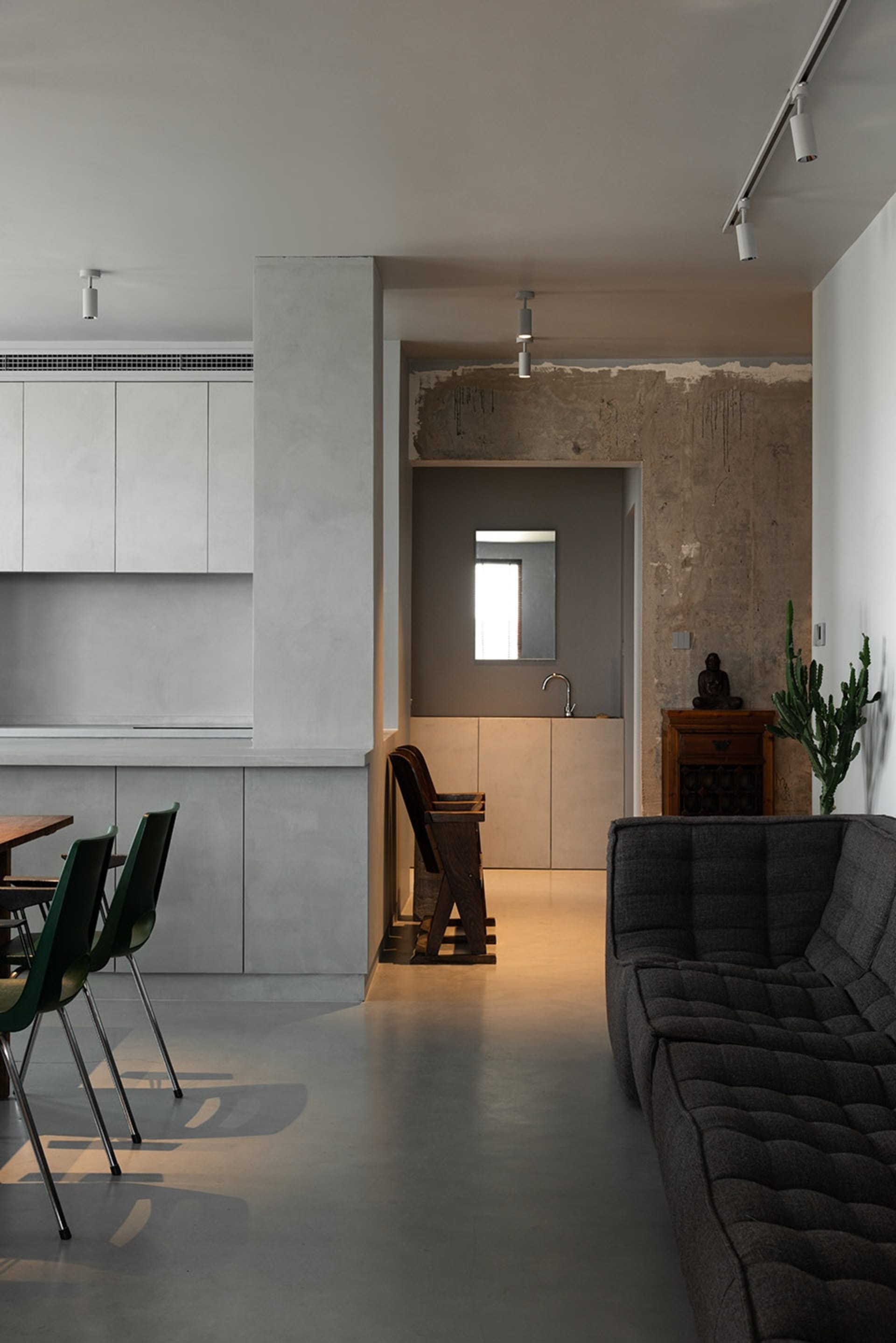 Modern living room with concrete walls and minimalist furniture.