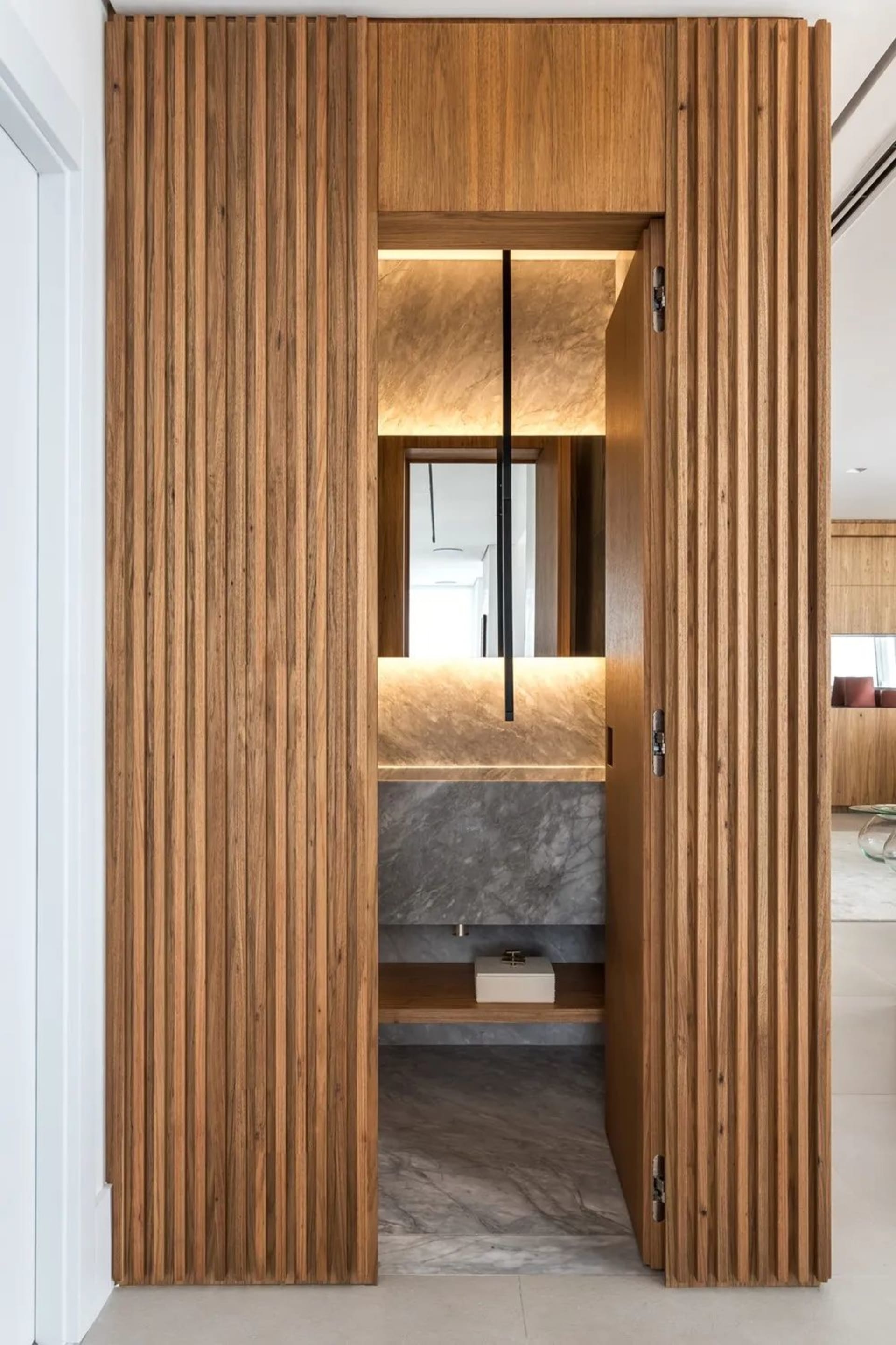 Modern bathroom with marble and wood finishes, featuring a sleek, minimalist design.