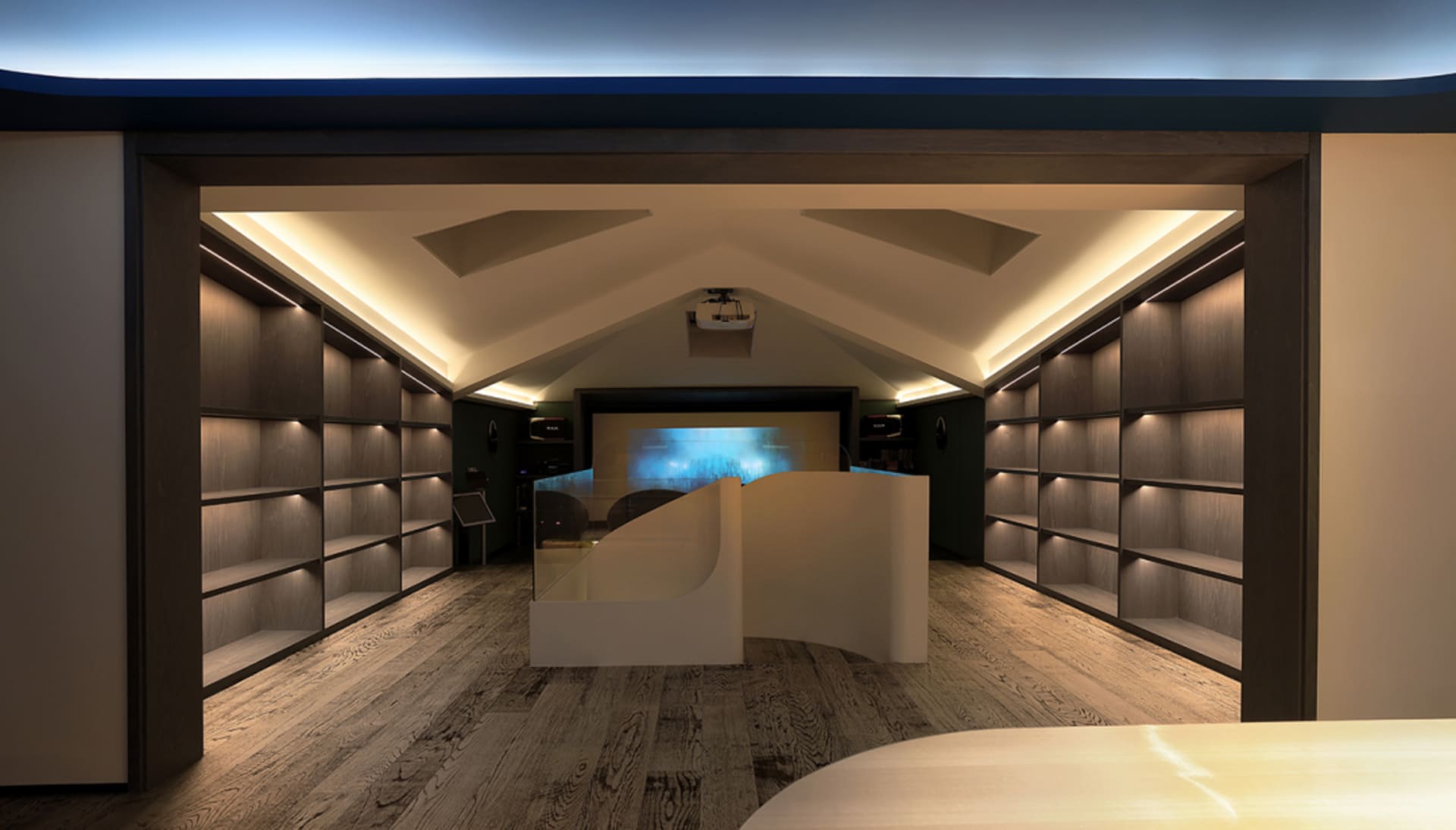A modern library with wooden-paneled shelves and a sleek, curved reception desk in the foreground.
