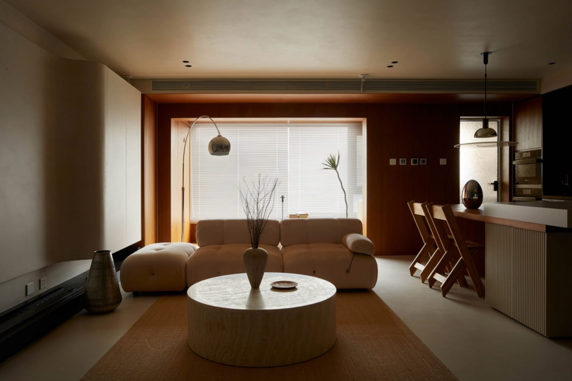 A modern living room with wooden furniture, a round coffee table, and minimalist decor.