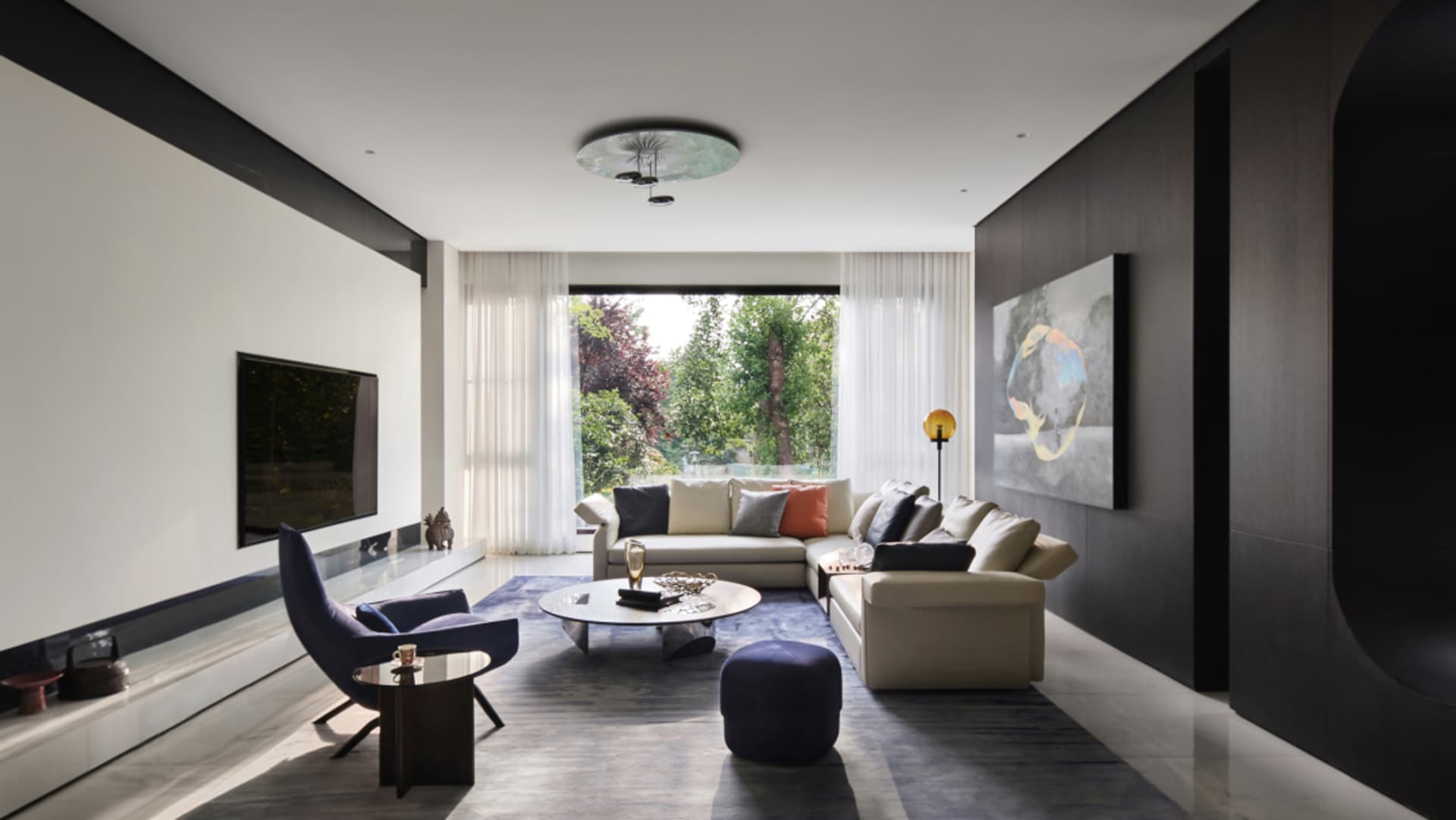 A modern minimalist living room with concrete, glass, and metal materials.