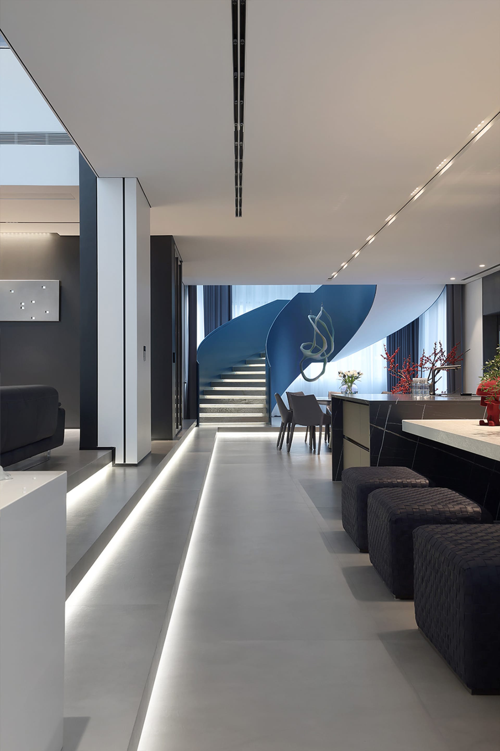 A minimalist, modern interior design featuring a concrete staircase and contemporary furniture.