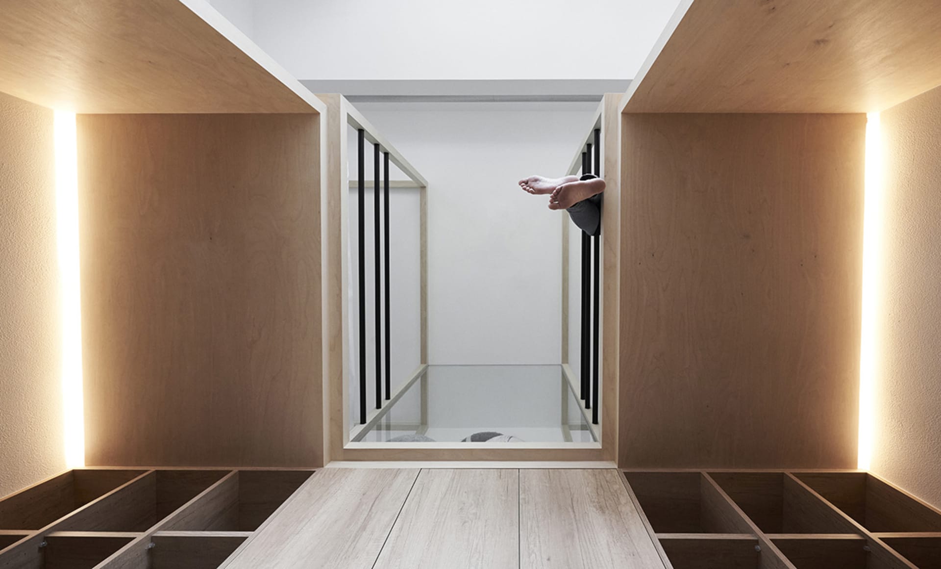A minimalist residential space featuring light-colored wood and white surfaces.