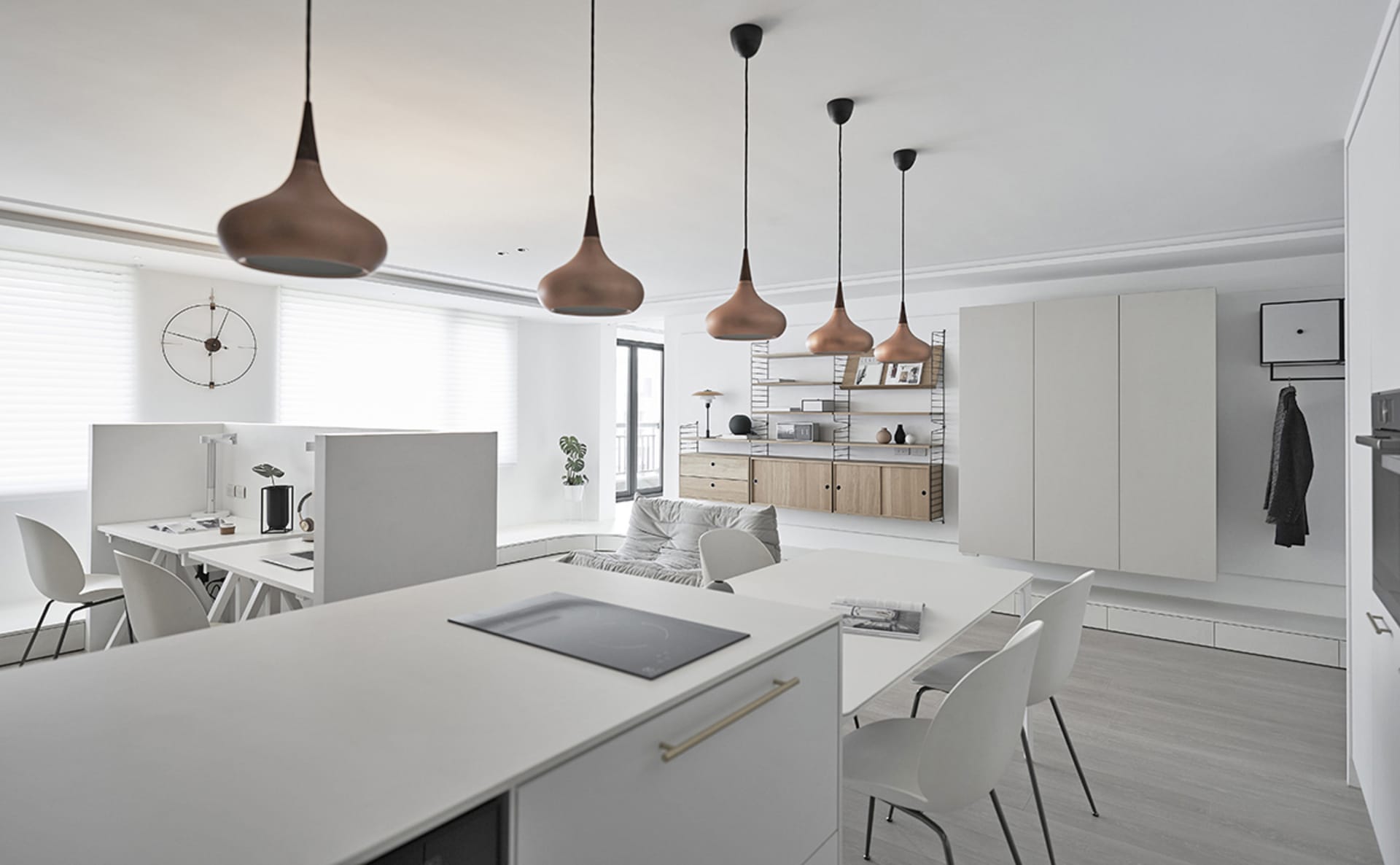 A modern office kitchen with white materials and minimalist design, featuring a white countertop, pendant lights, and a white