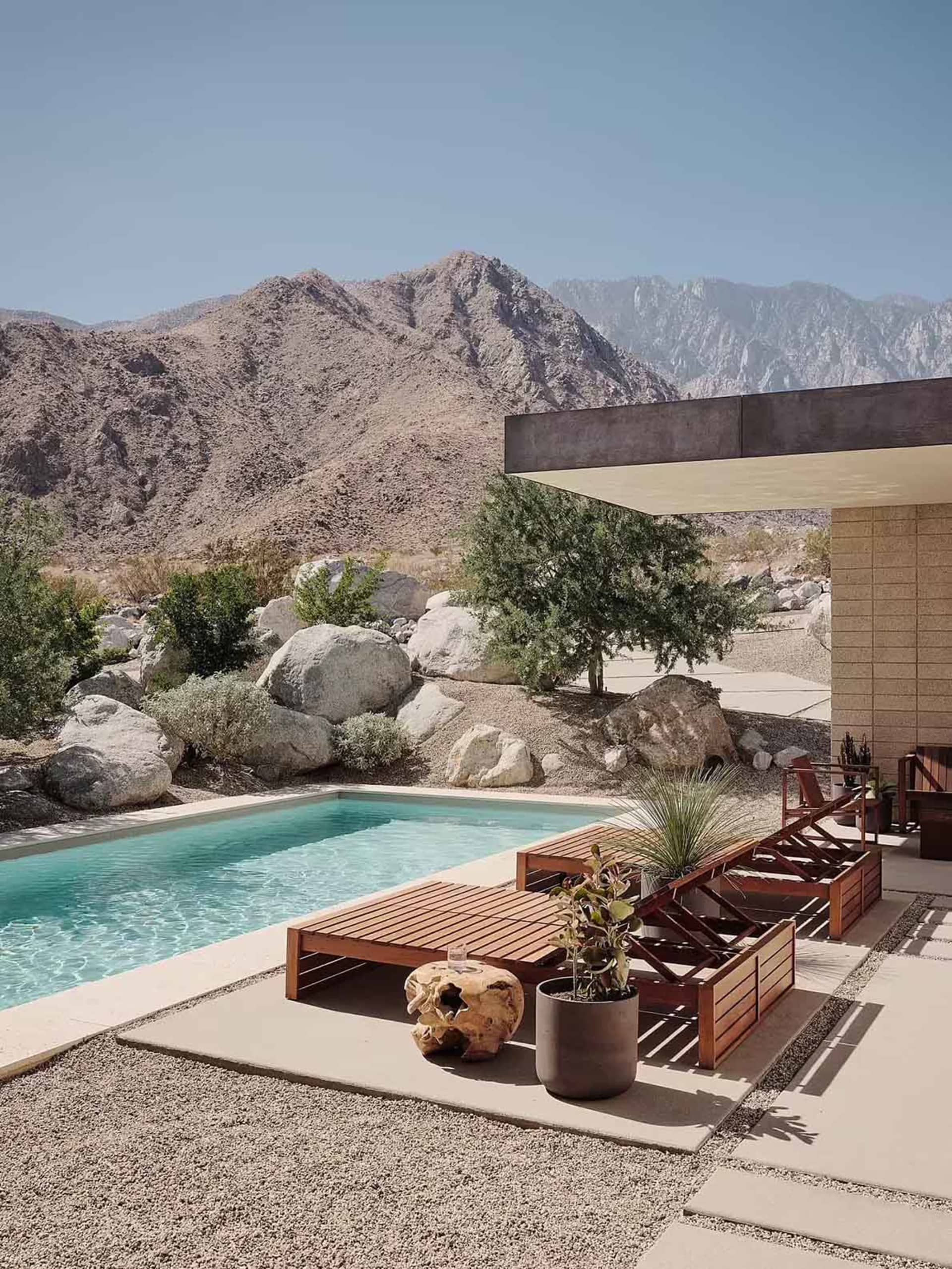 A modern residential pool area featuring concrete materials and minimalist design.