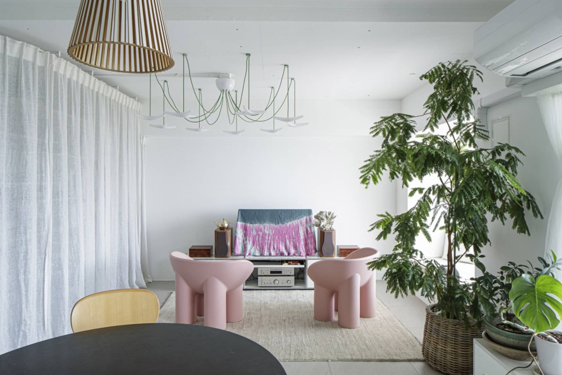 A modern living room featuring wooden furniture, concrete geometric shapes, and fabric seating.