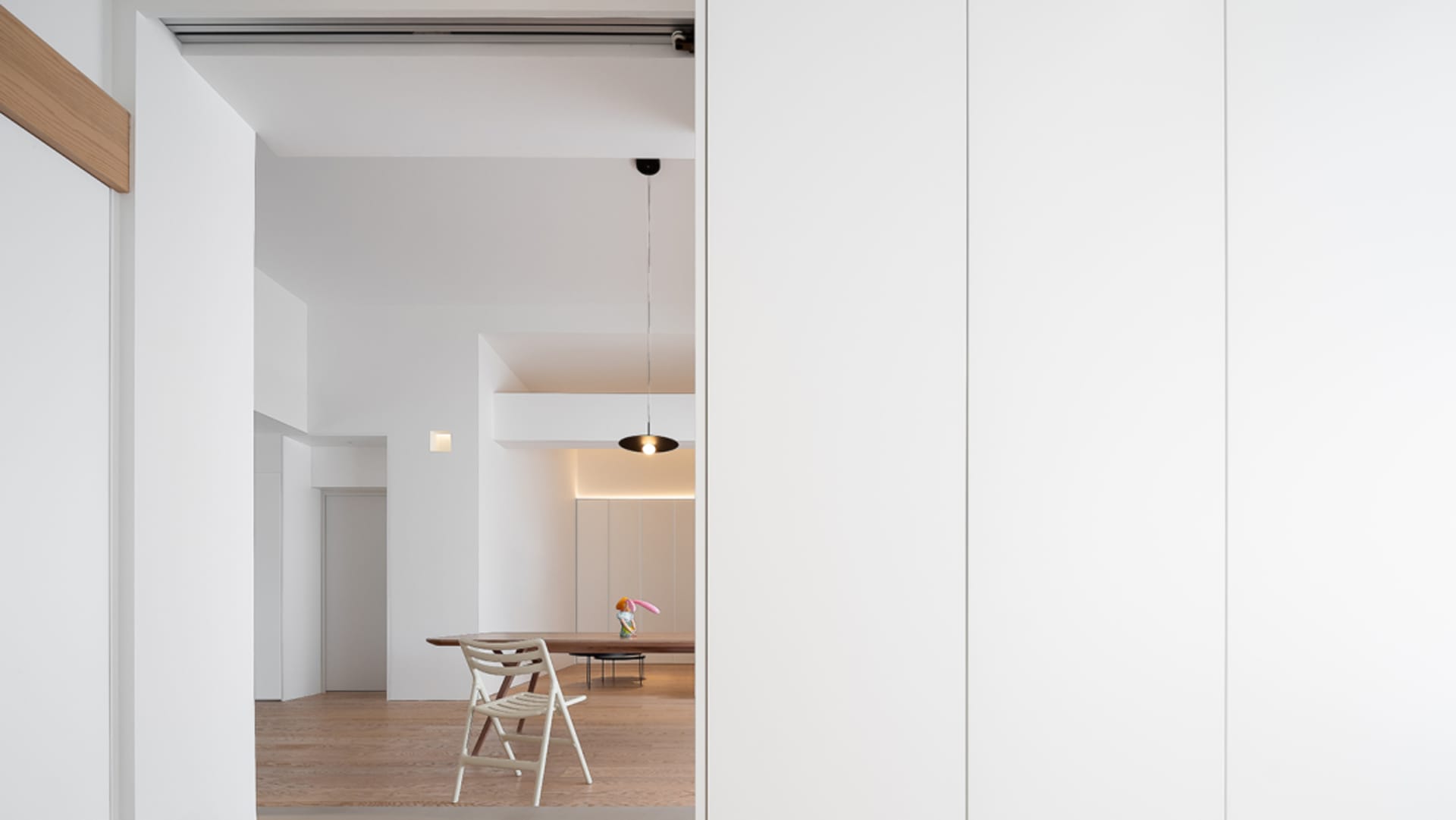 A modern residential dining room with wooden furniture and concrete flooring