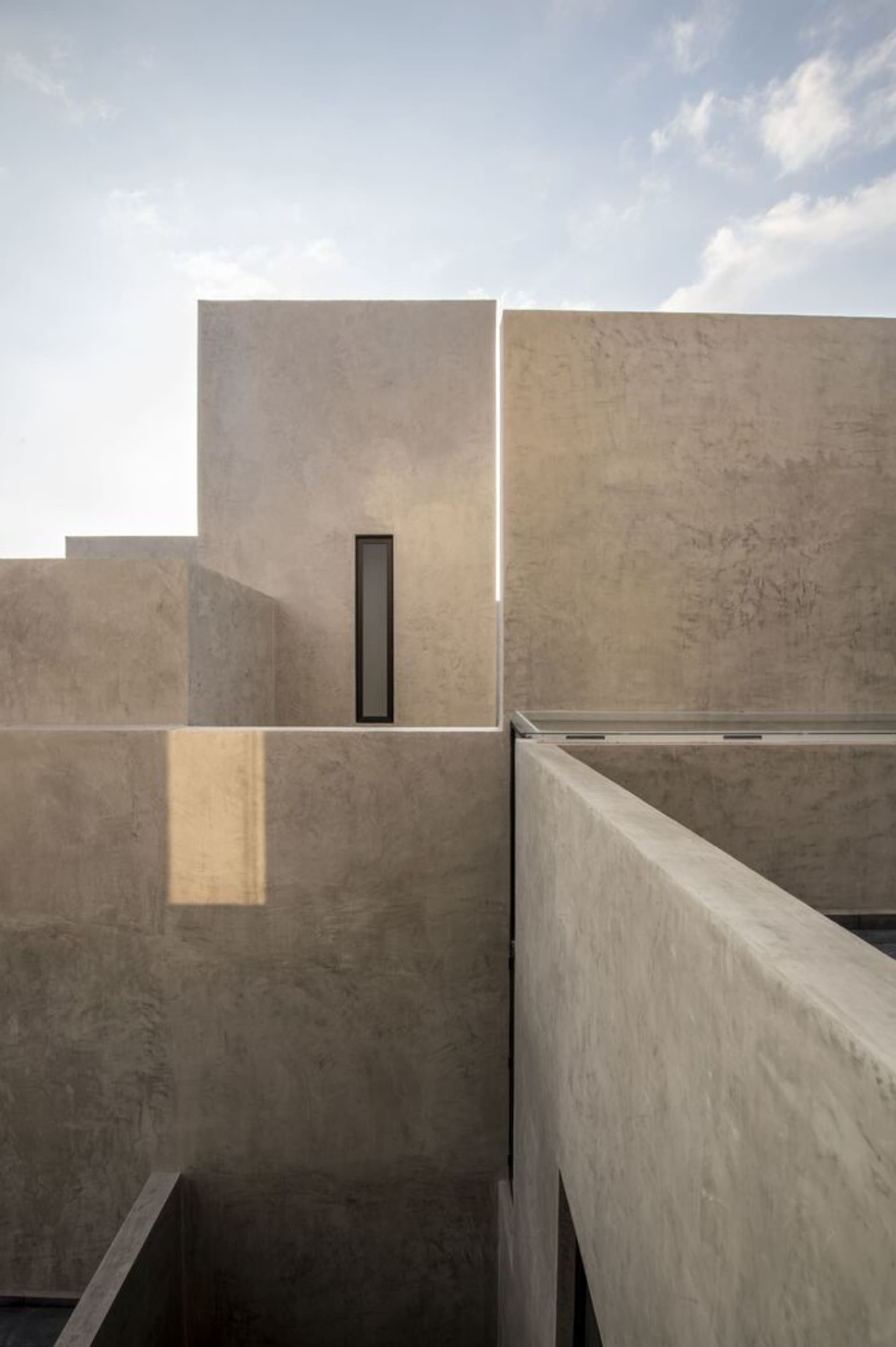 Modern minimalist building with concrete exterior and narrow window.