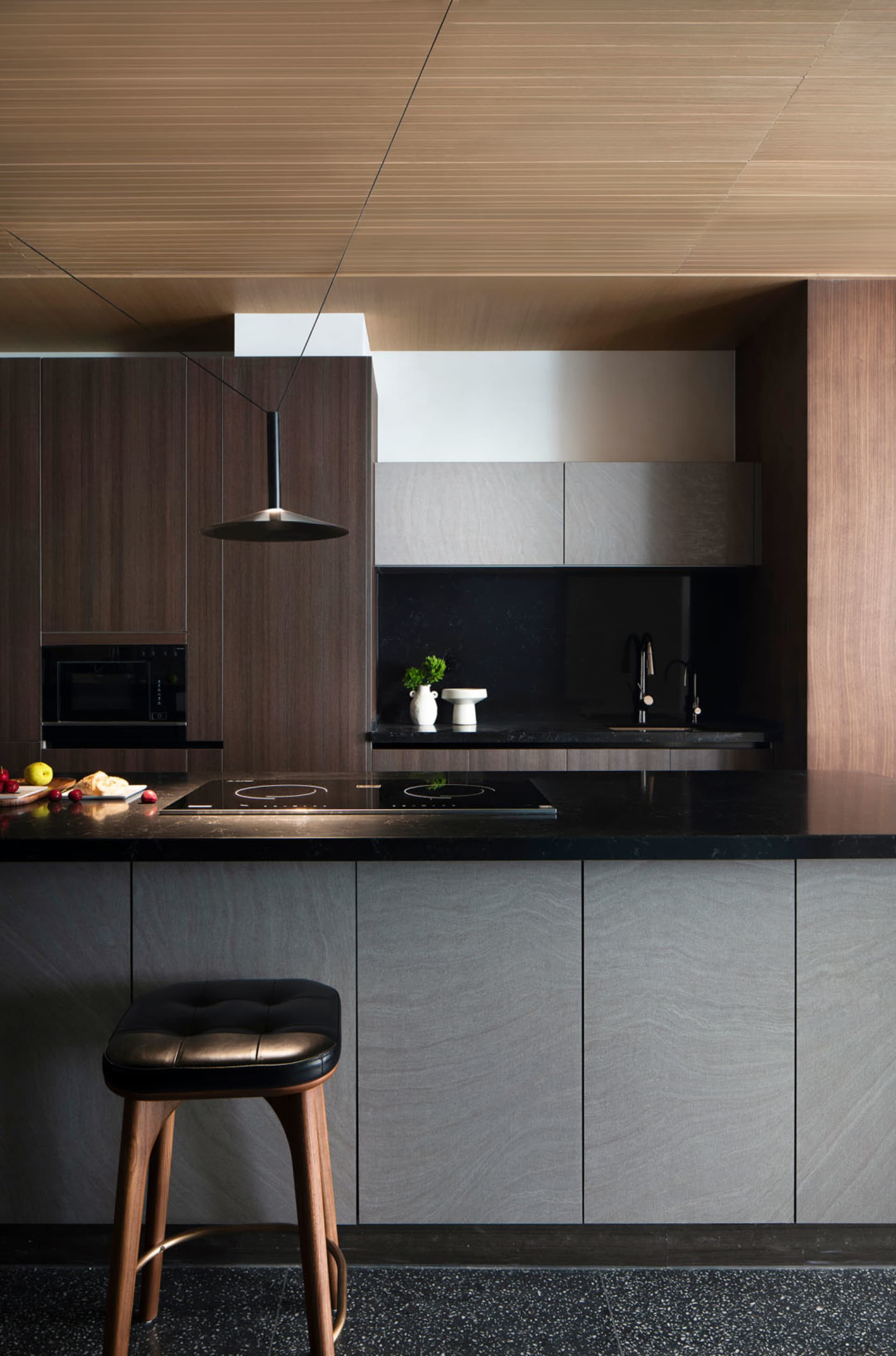 A modern kitchen featuring black marble countertops and minimalist design elements.