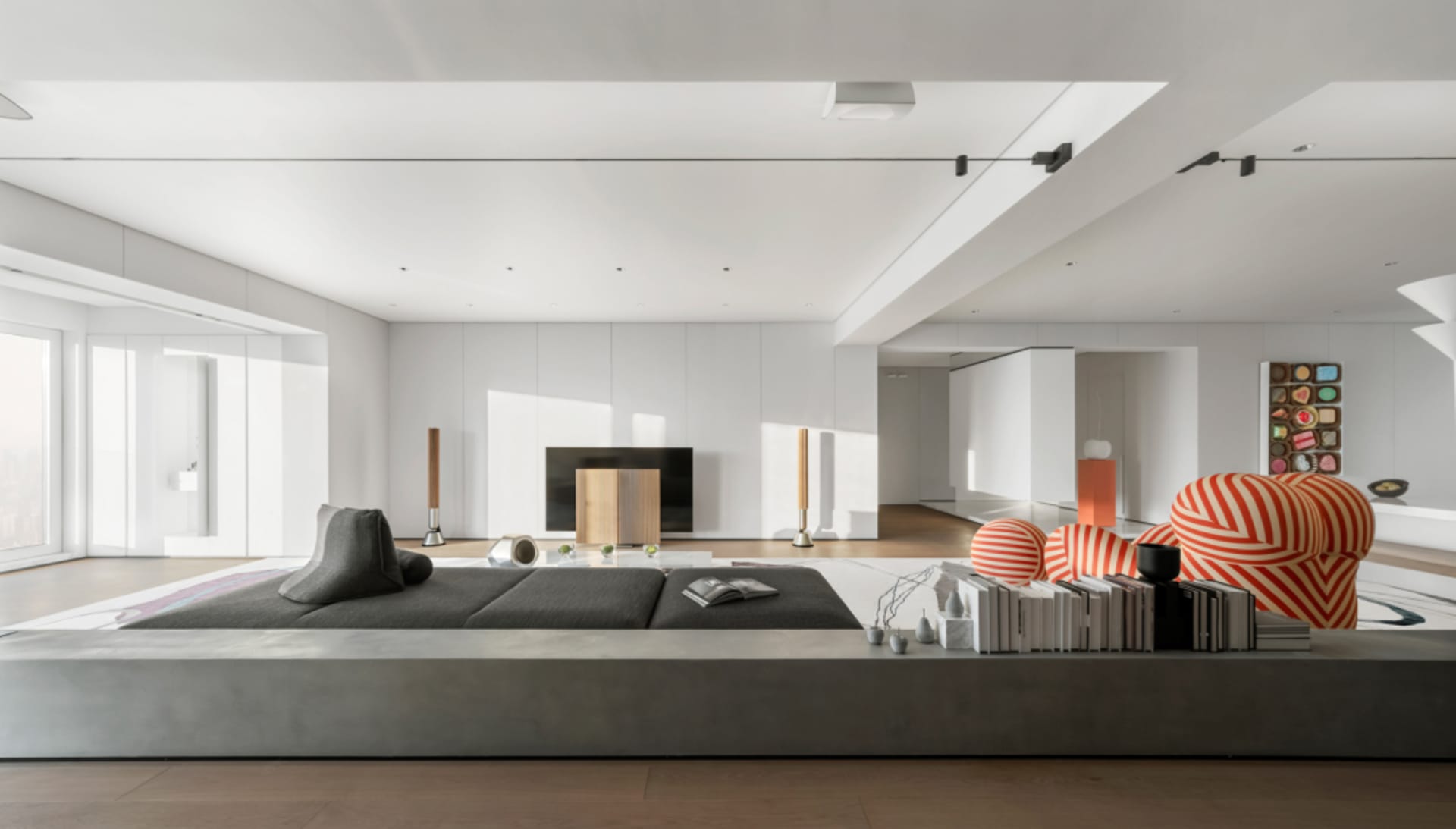 Modern living room with concrete seating, minimalist decor, and high ceilings.