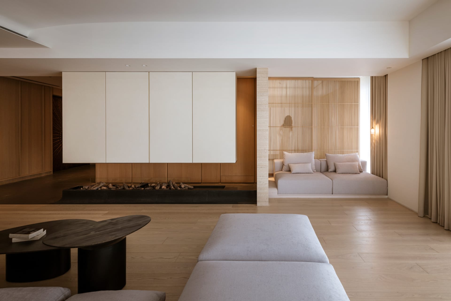 Modern living room featuring two white sofas with light-colored cushions against a wooden background with white paneling on t
