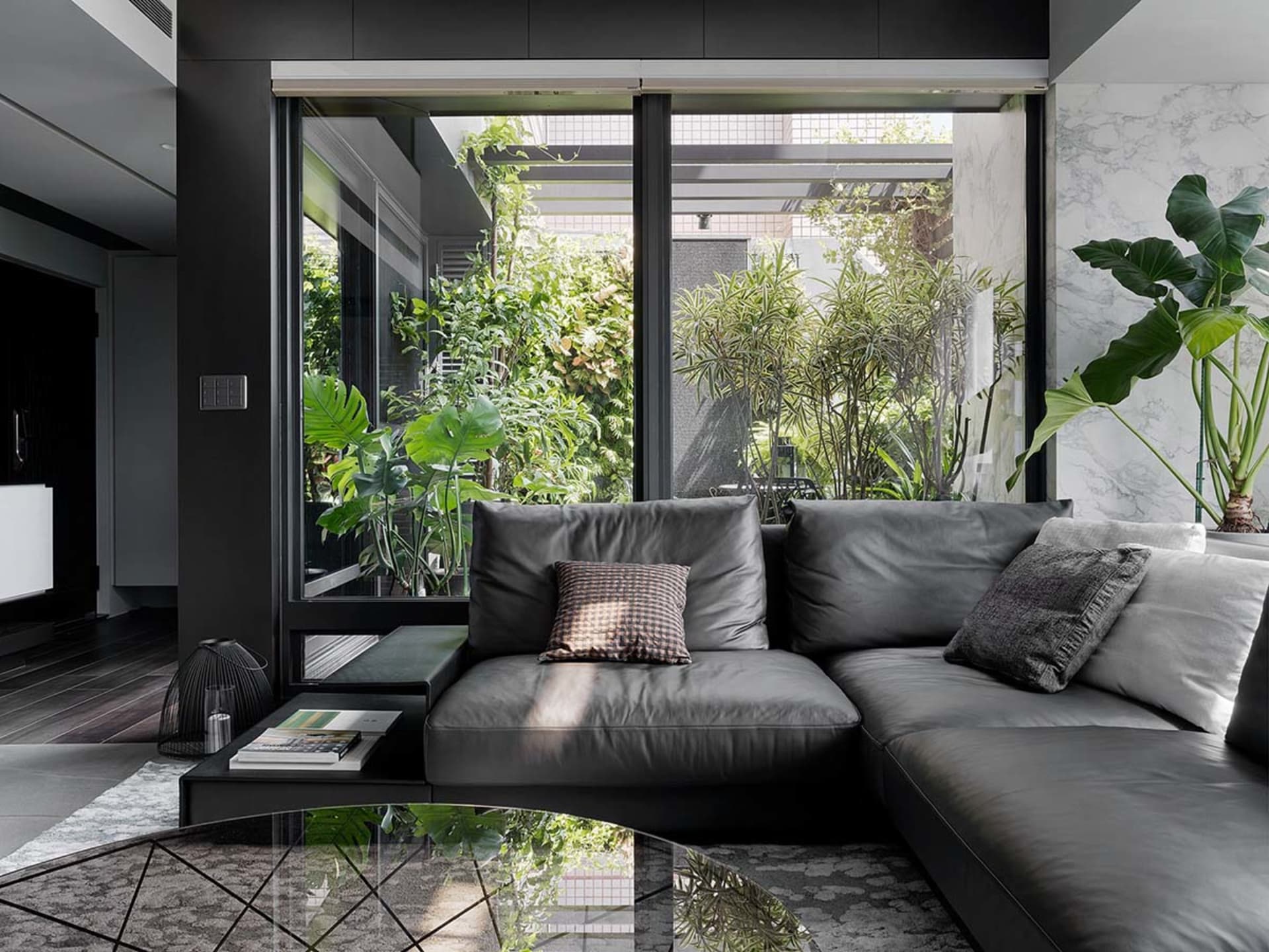 Contemporary black leather sectional sofa adorned with textured cushions, situated in a well-lit, contemporary living room fe