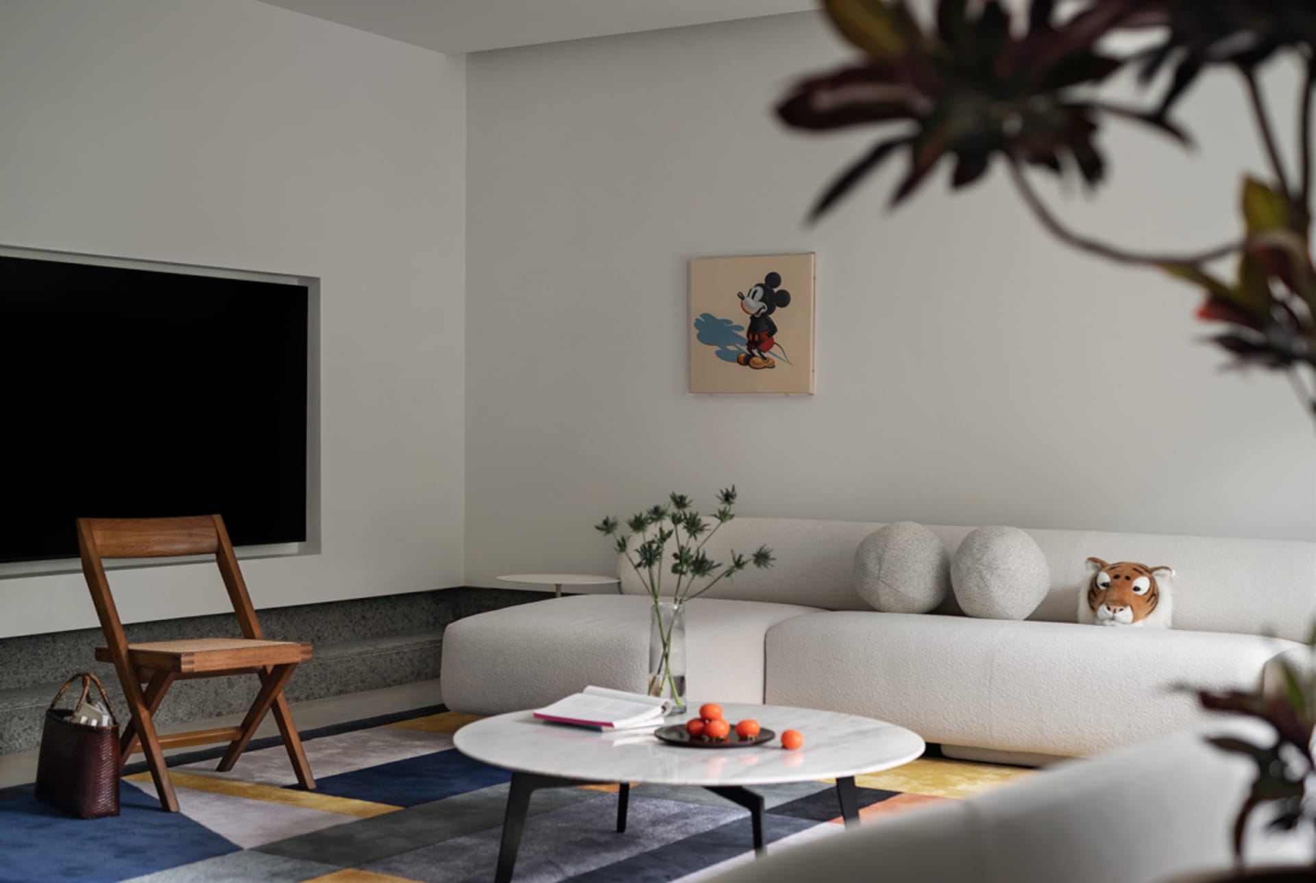 A modern Scandinavian-style living room with textured fabric furniture, a minimalist color palette, and decorative plants.