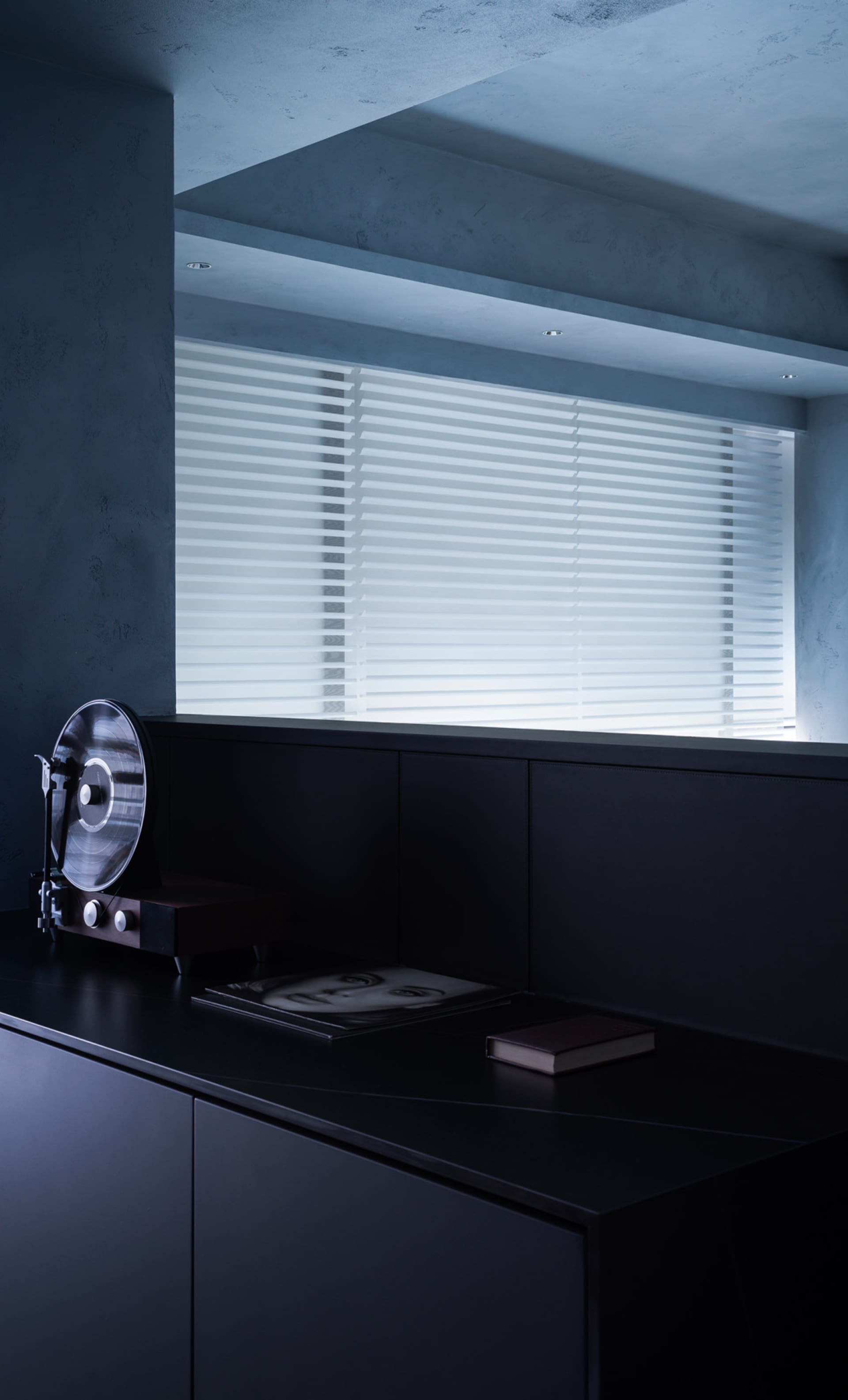 A minimalistic, industrial-style black interior moodboard featuring a record player, a record, and a book on a window sill wi