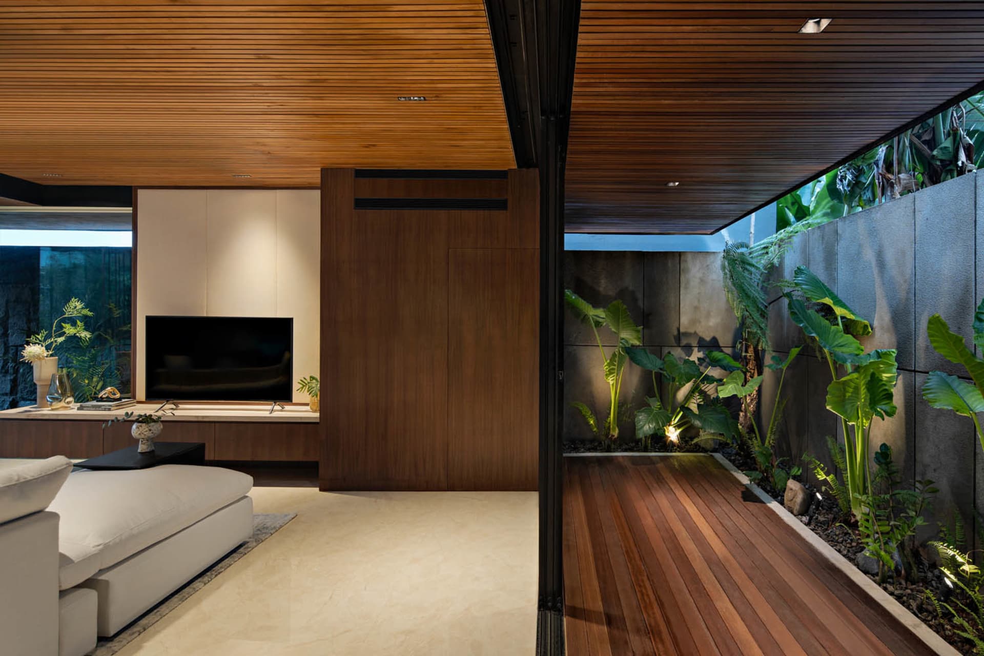 A modern living room featuring wooden elements and a private garden section.