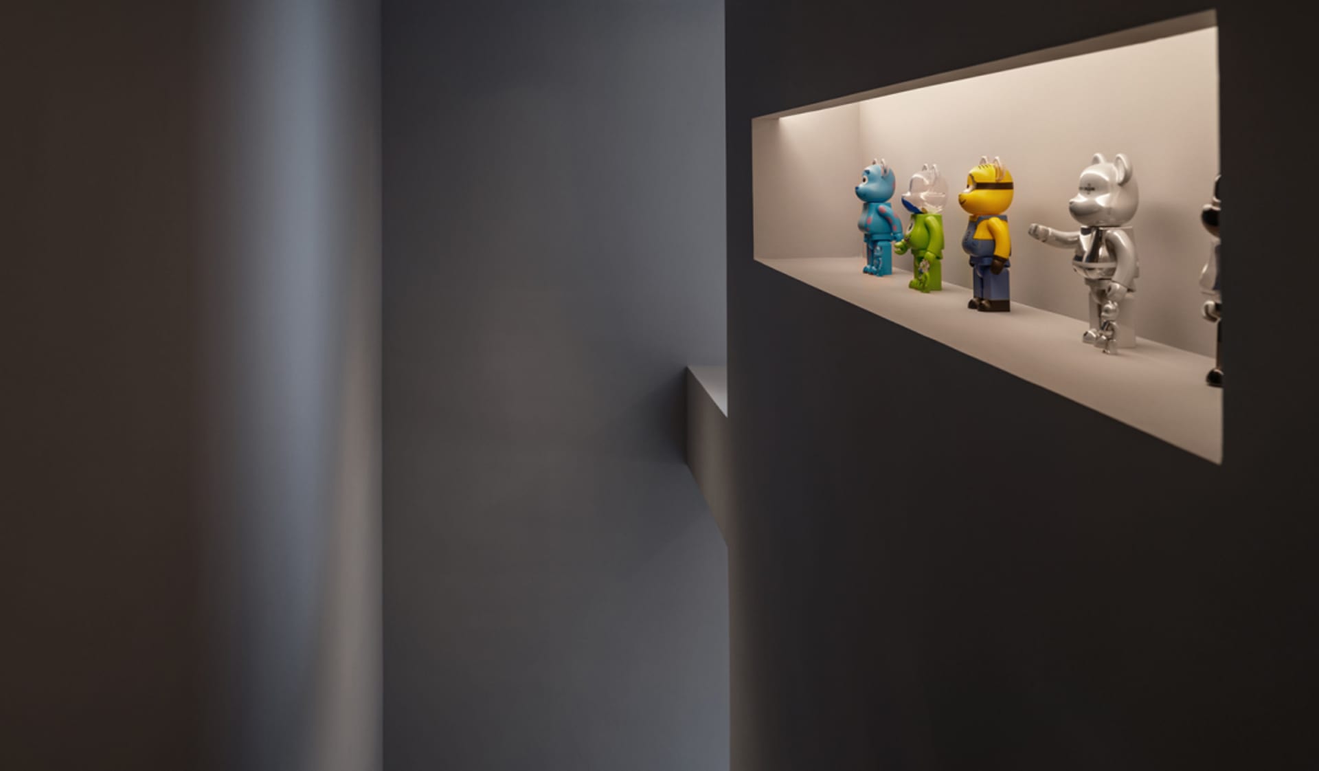 A minimalist display features various colorful toy figures.