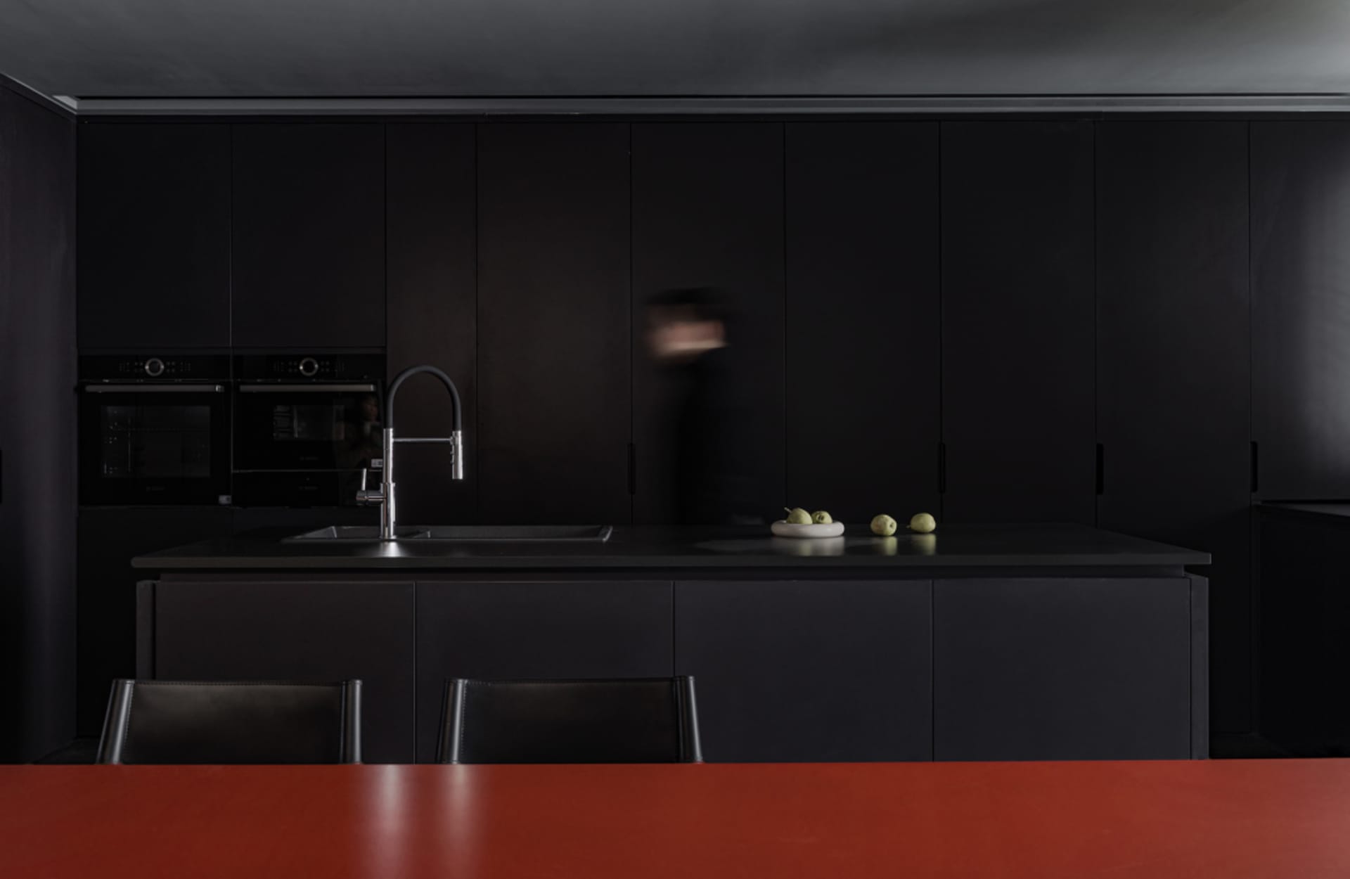 Contemporary kitchen with black cabinets and countertops.