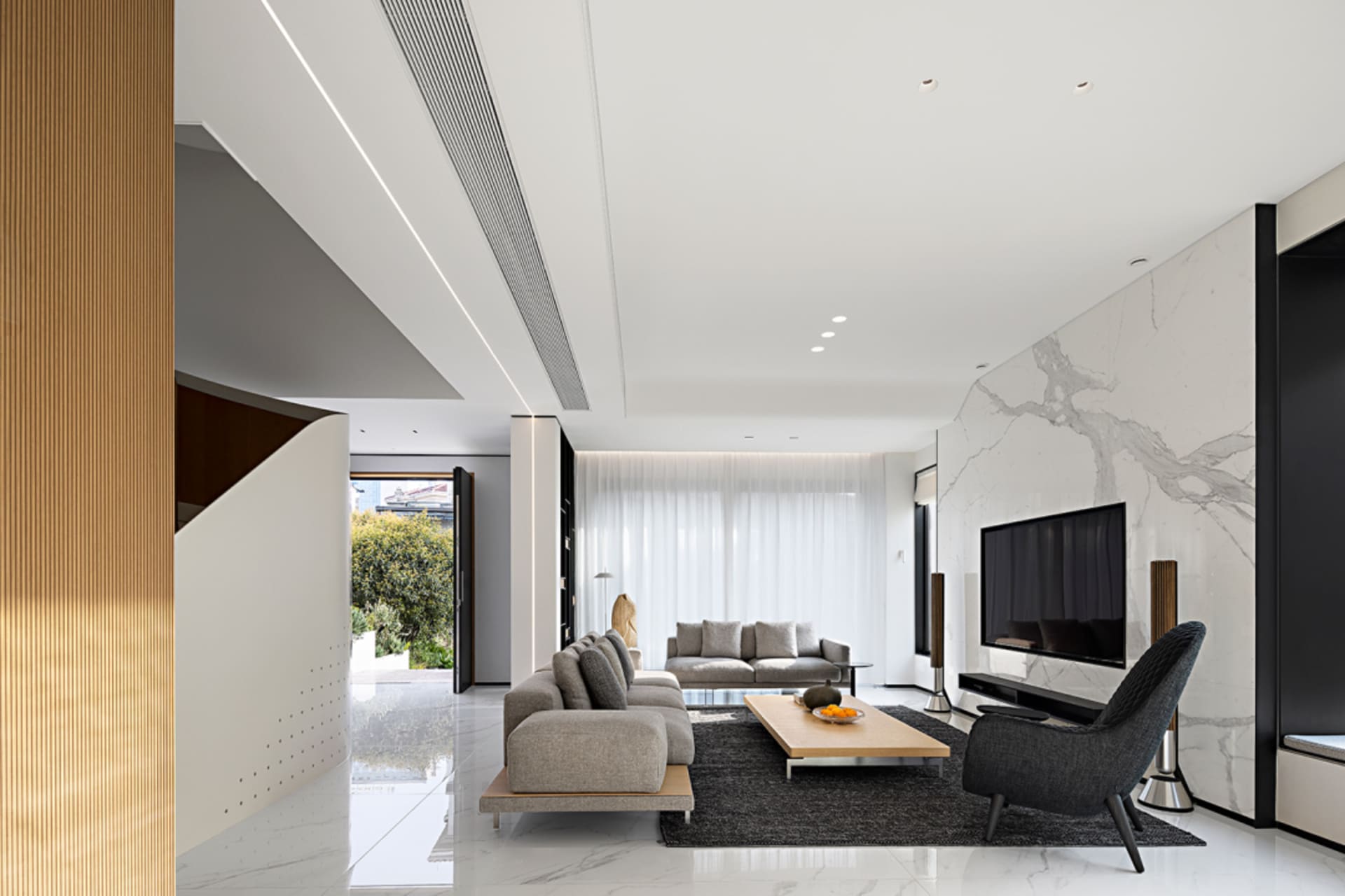 A modern living room with marble furniture and floor.