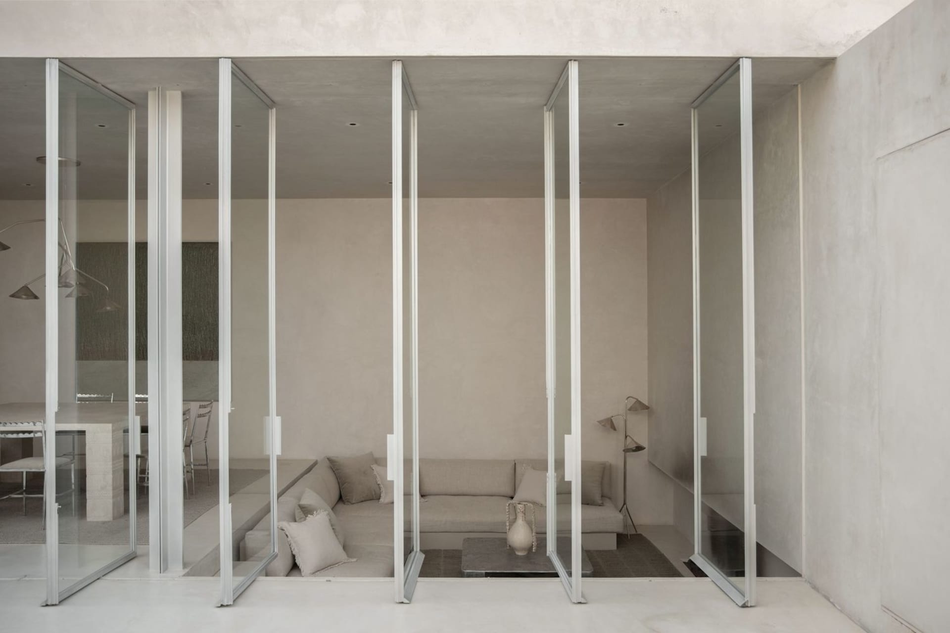 Modern minimalist living room with concrete walls and floor.