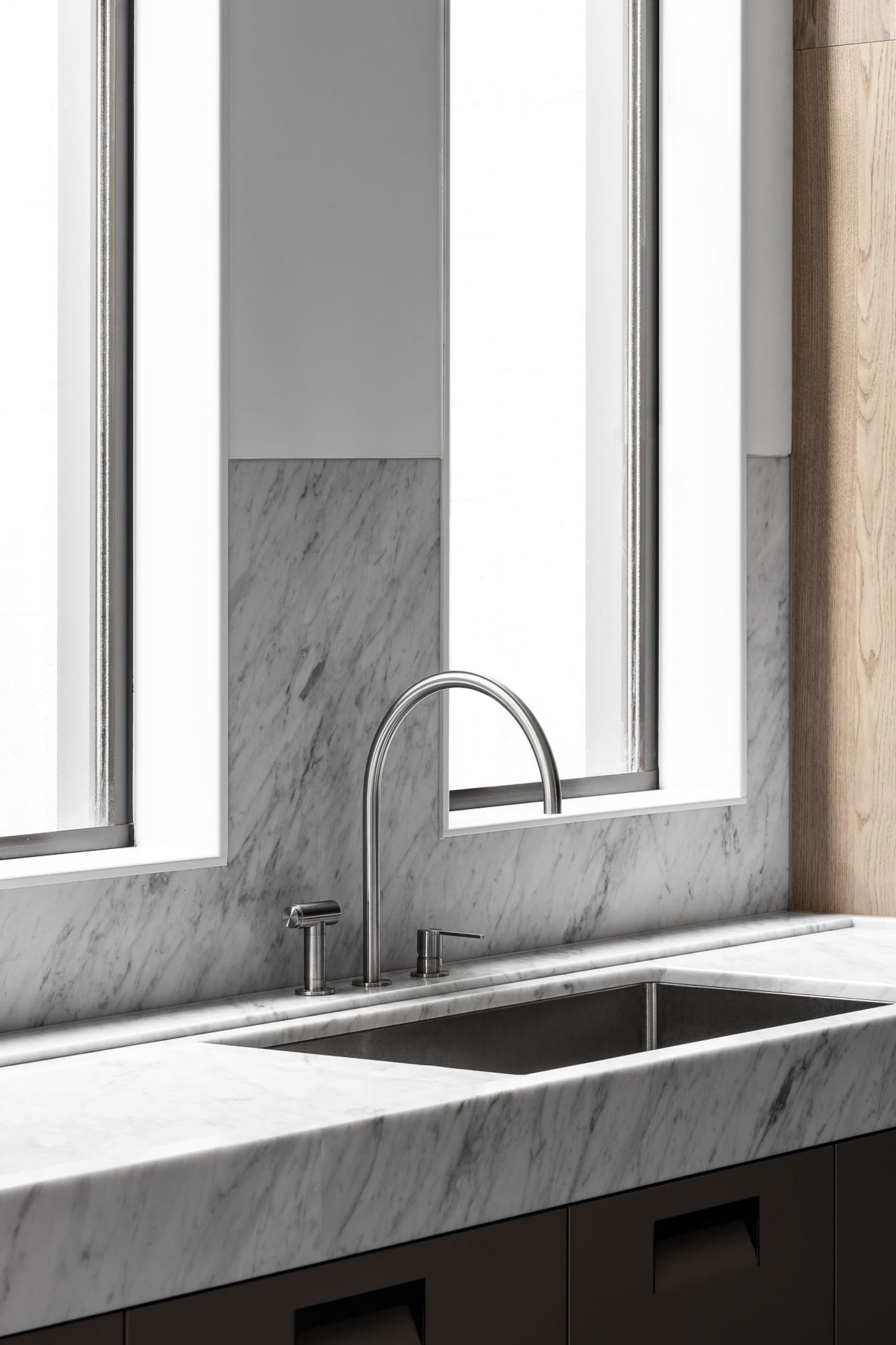 Modern kitchen featuring marble countertops and backsplash with a sleek, minimalistic design.