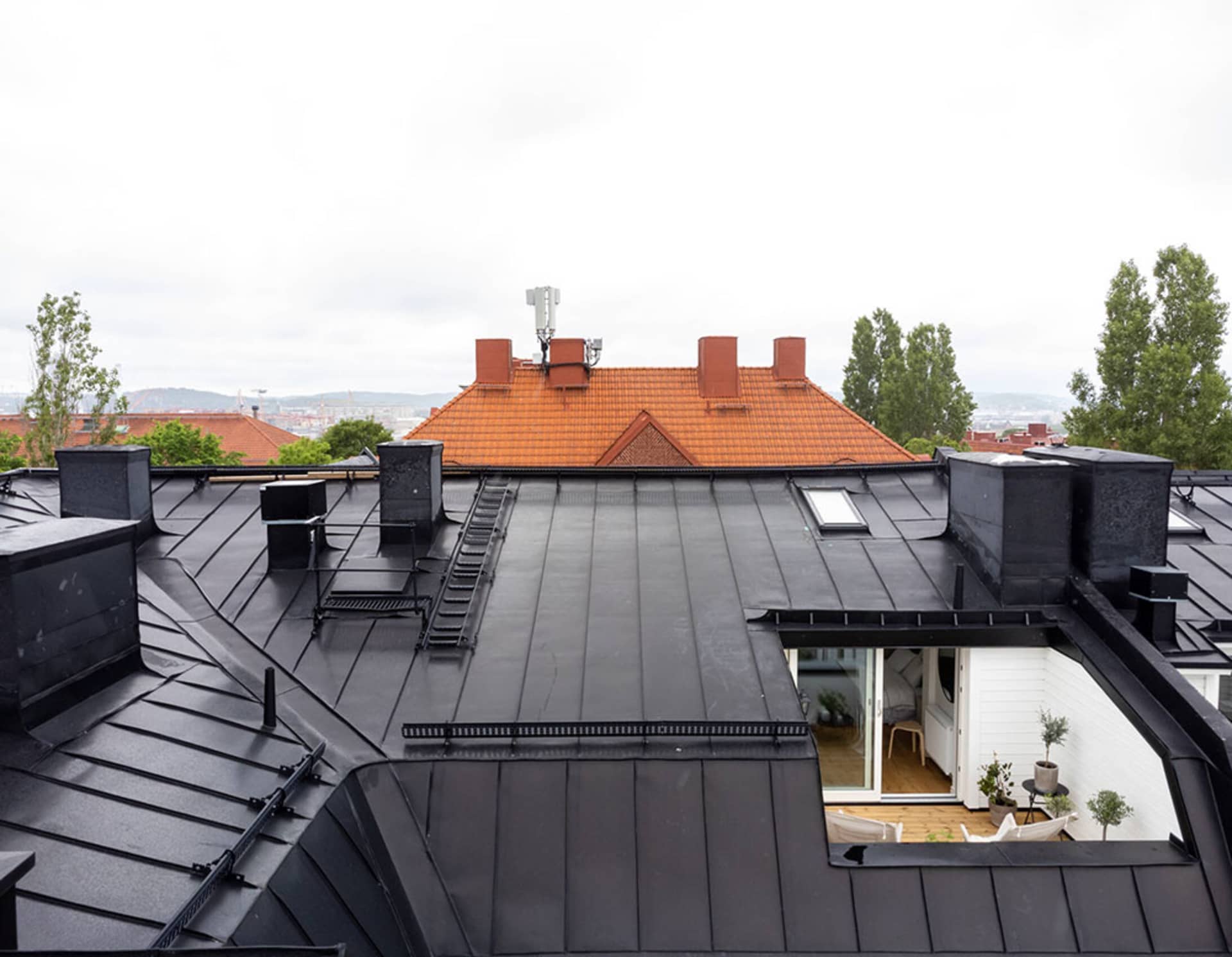 A modern rooftop featuring black metal roofing materials.