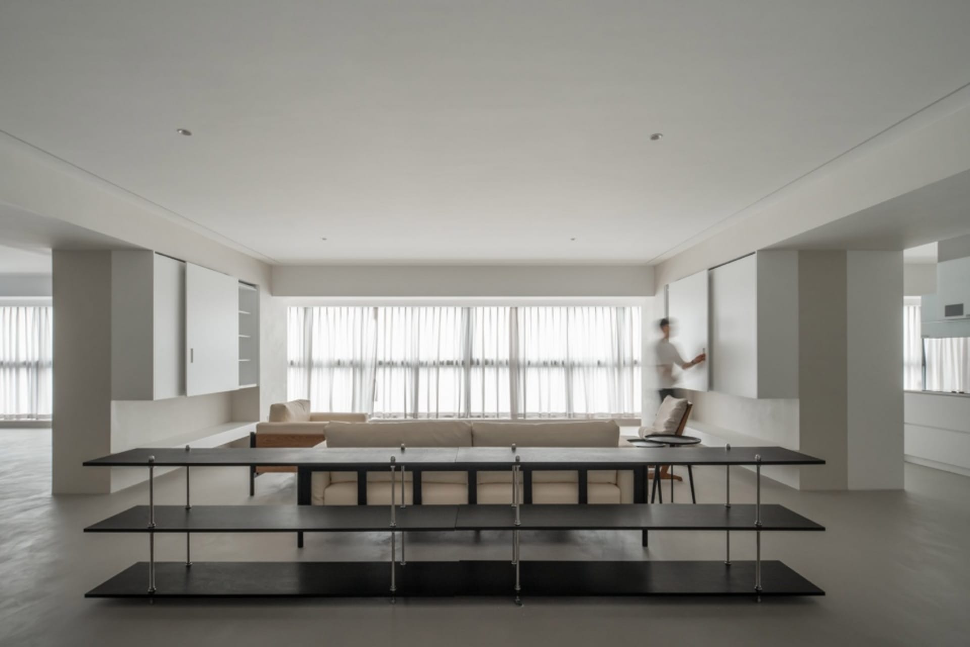 A modern living room with neutral-colored furniture and a minimalist design.