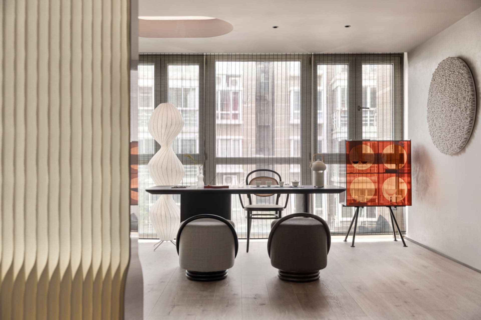 Modern dining room featuring a wooden table and chairs, with a contemporary chandelier and minimalist decor.
