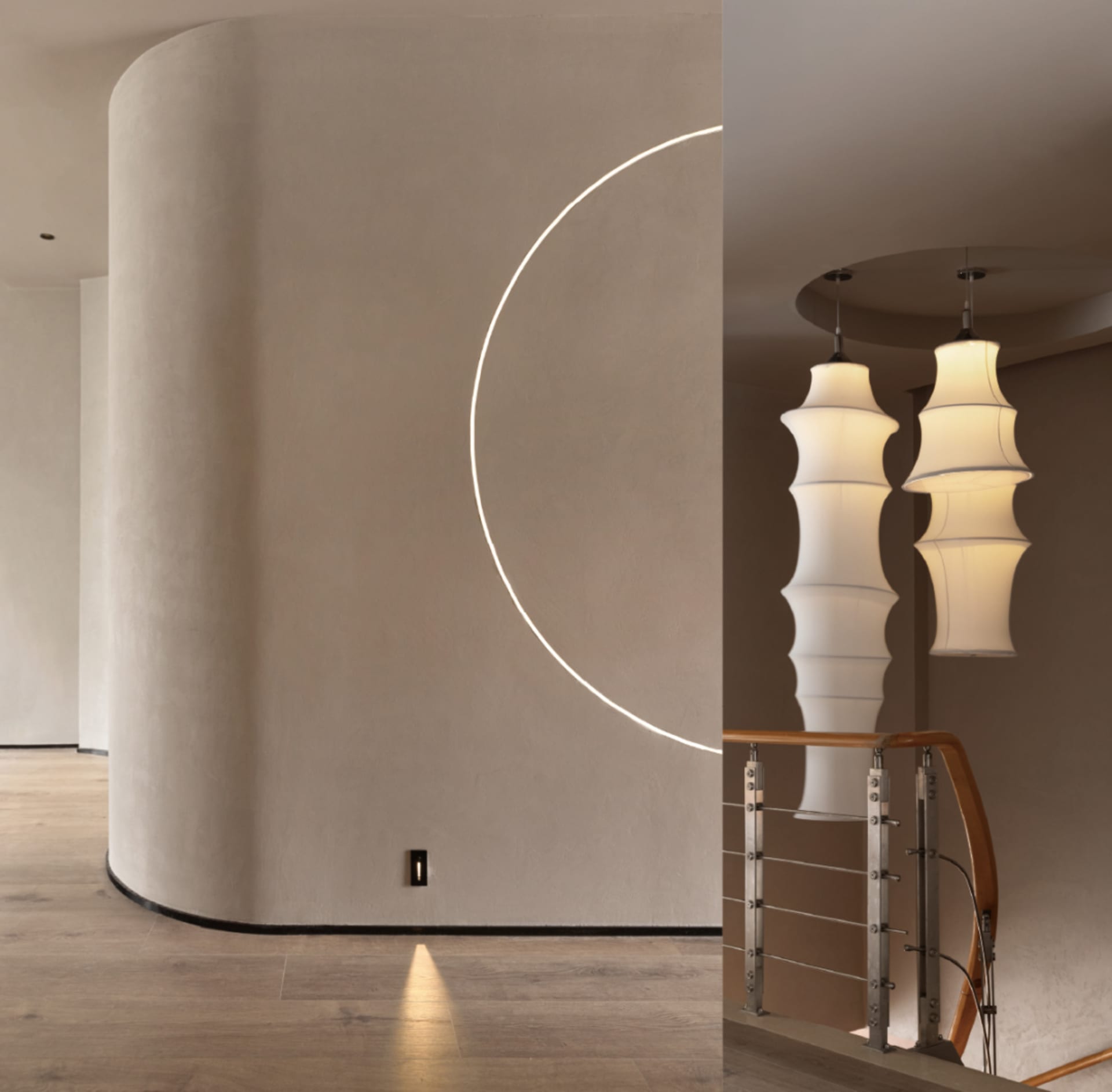 A modern interior design featuring a staircase illuminated by elegant, cylindrical pendant lights.