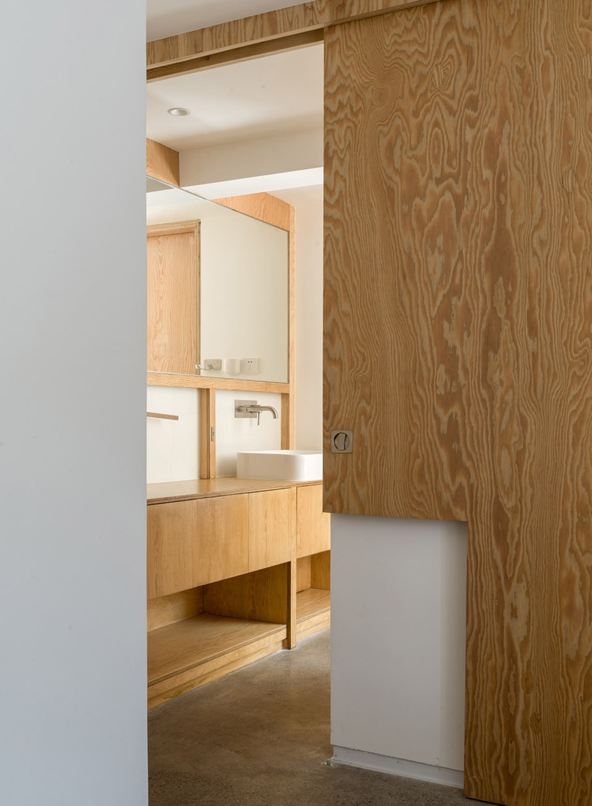 Minimalist bathroom featuring wooden elements and a clean, modern design.
